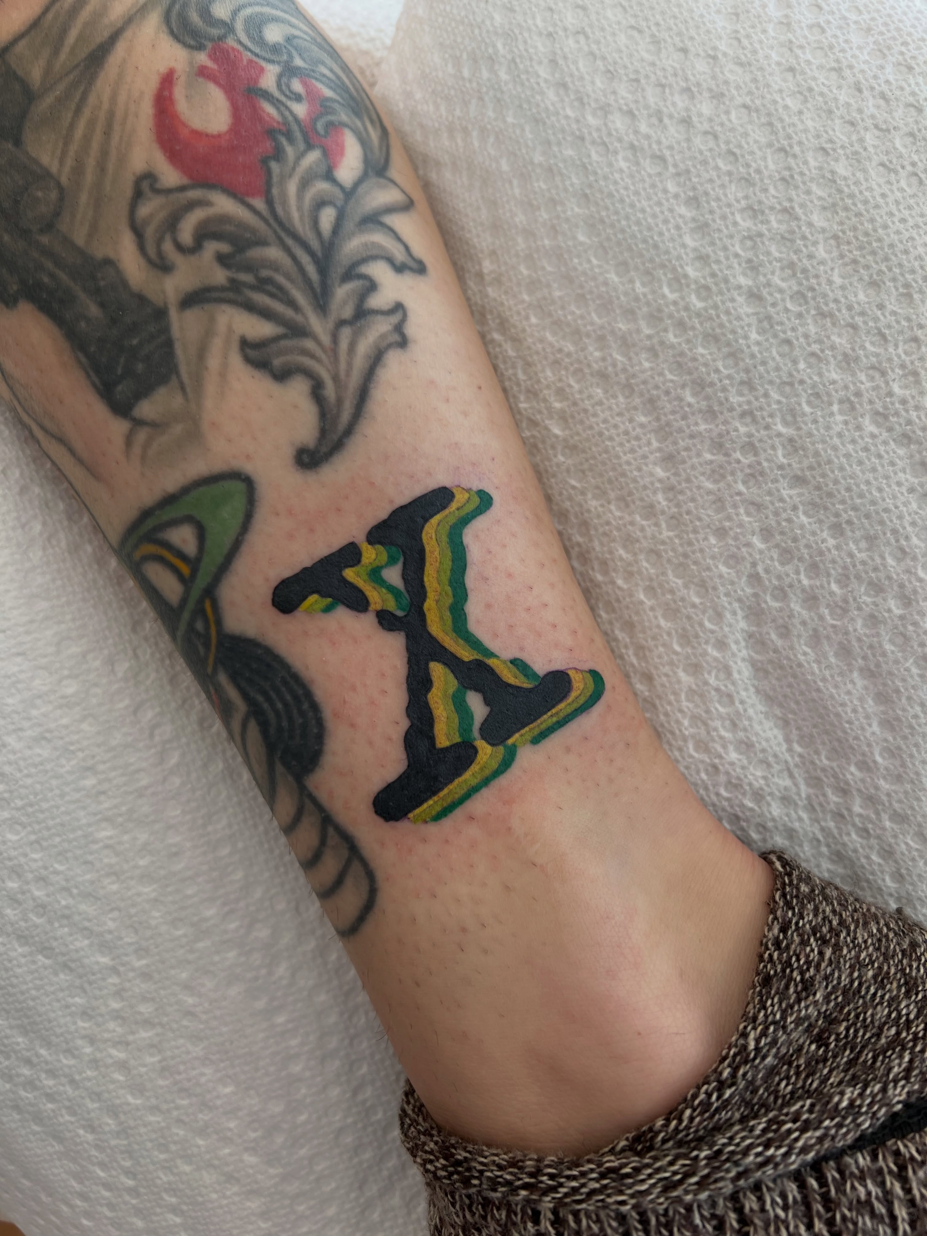 Letter 'K' new school tattoo on the forearm by Tattoo Artist