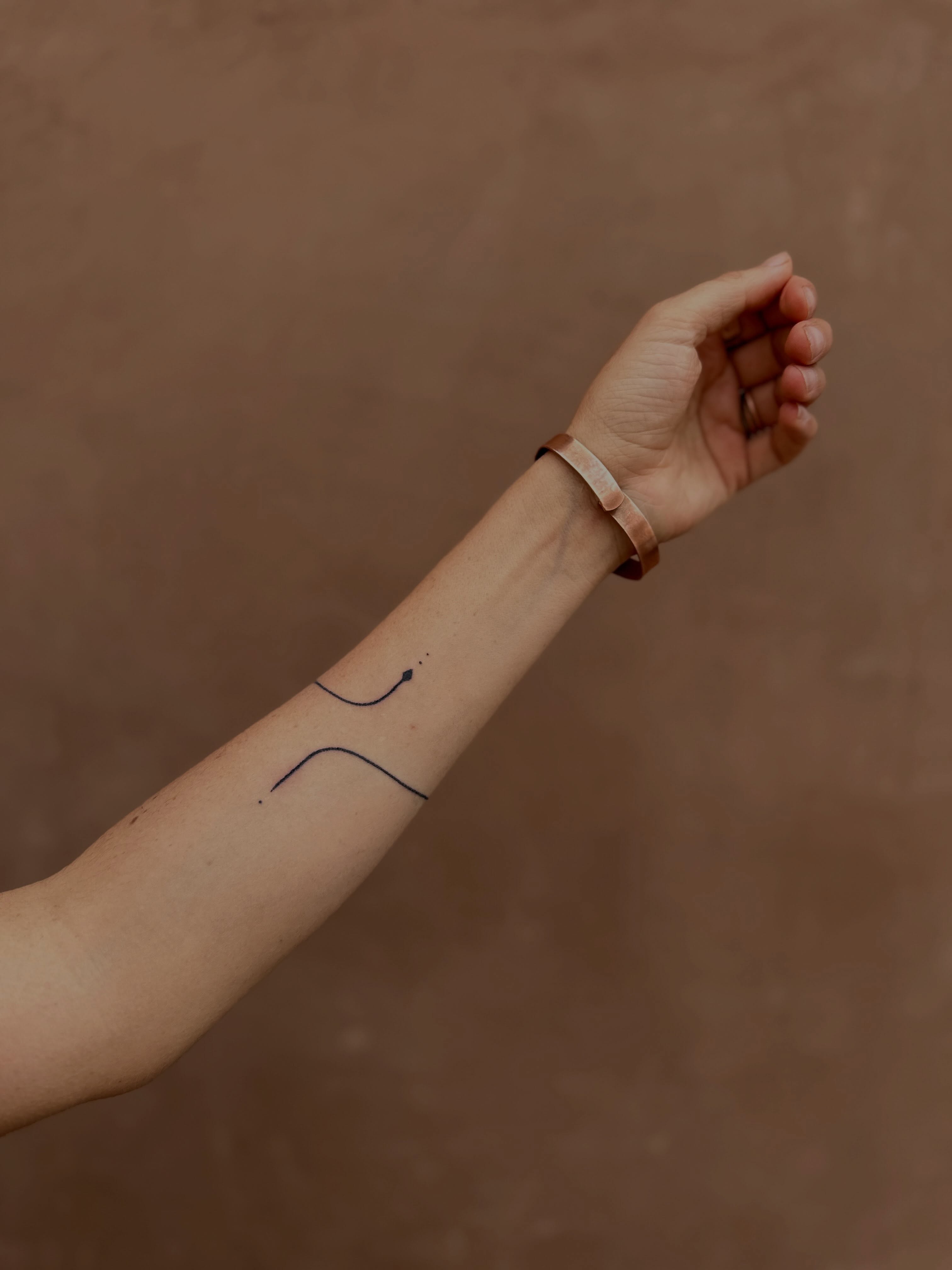 Abstract line minimalist tattoo on the forearm by Gaya