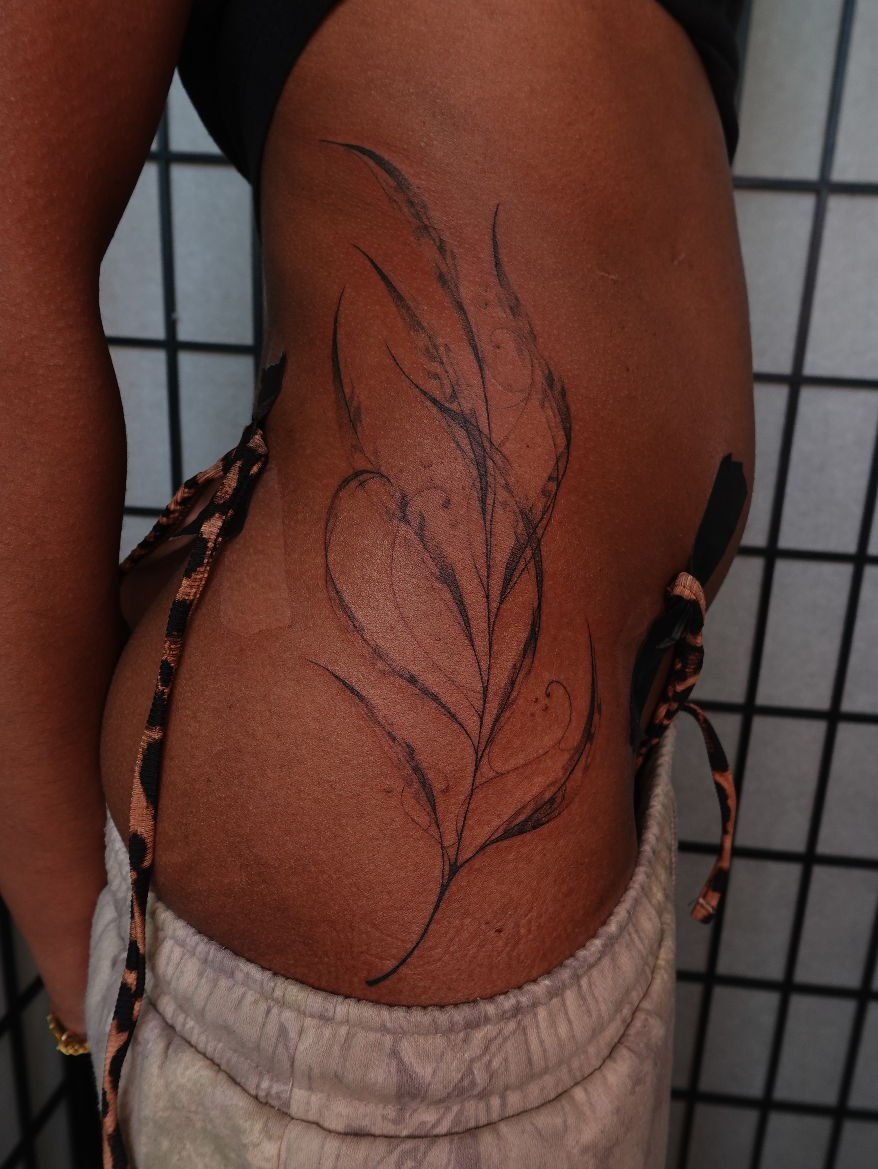 Feather black and grey tattoo on the thigh by jun