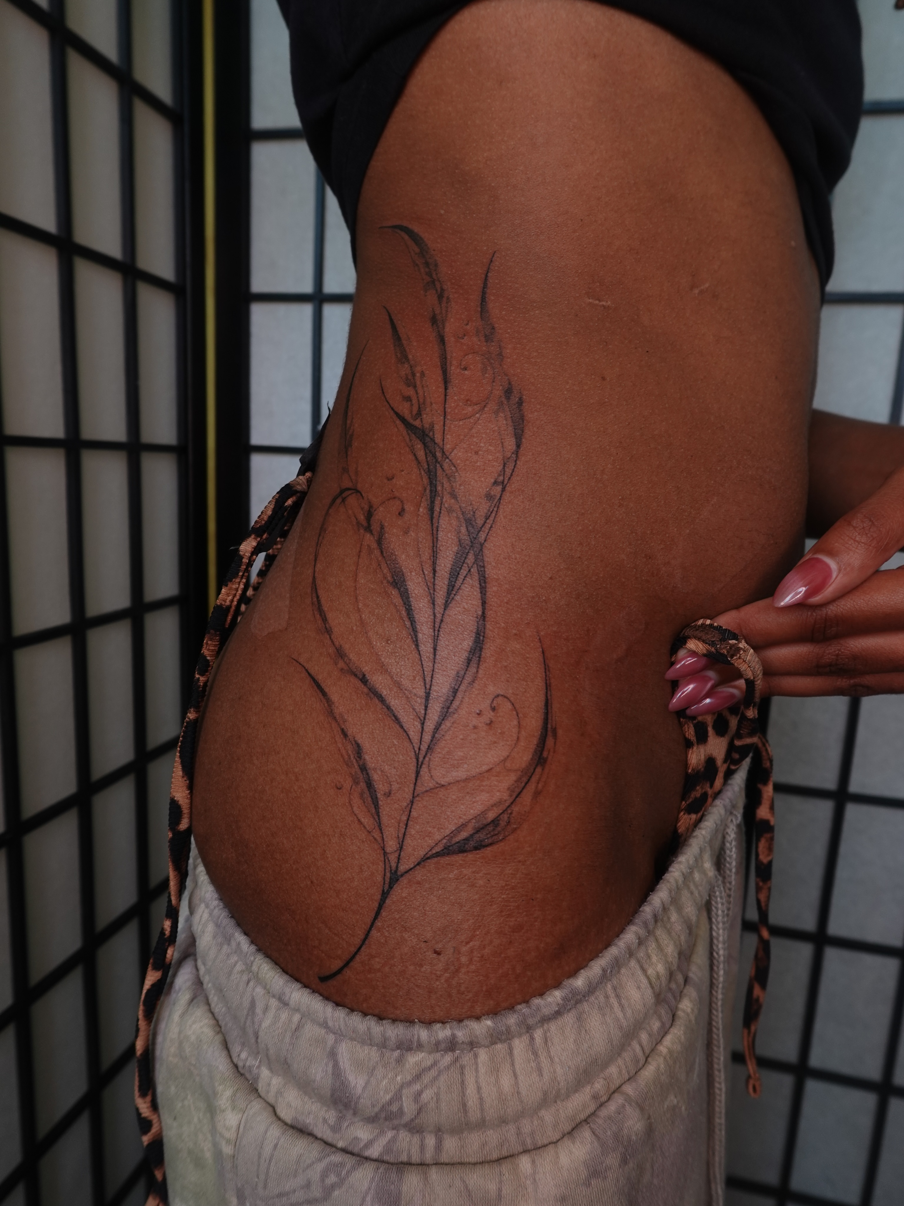 Feather black and grey tattoo on the thigh by jun