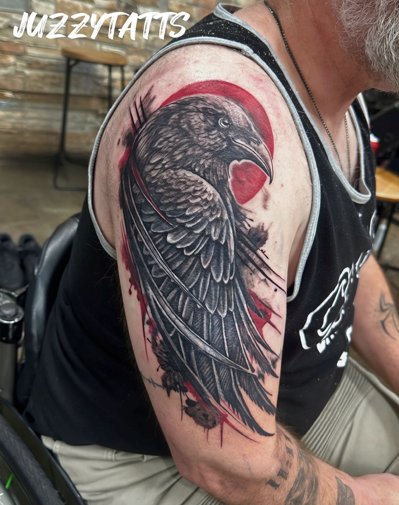 Crow realism tattoo on the upper arm by Justin Smith