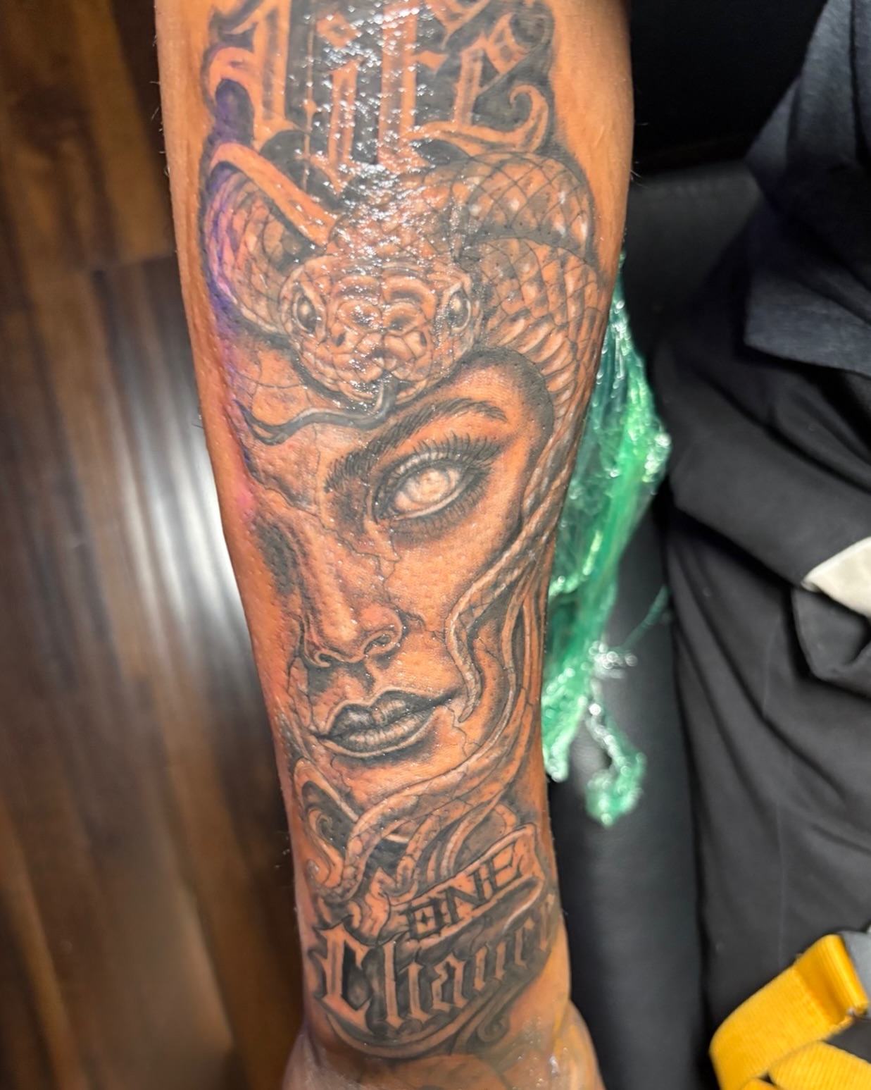 Woman with snake headdress realism tattoo on the forearm by K.L Tattoo Uptown