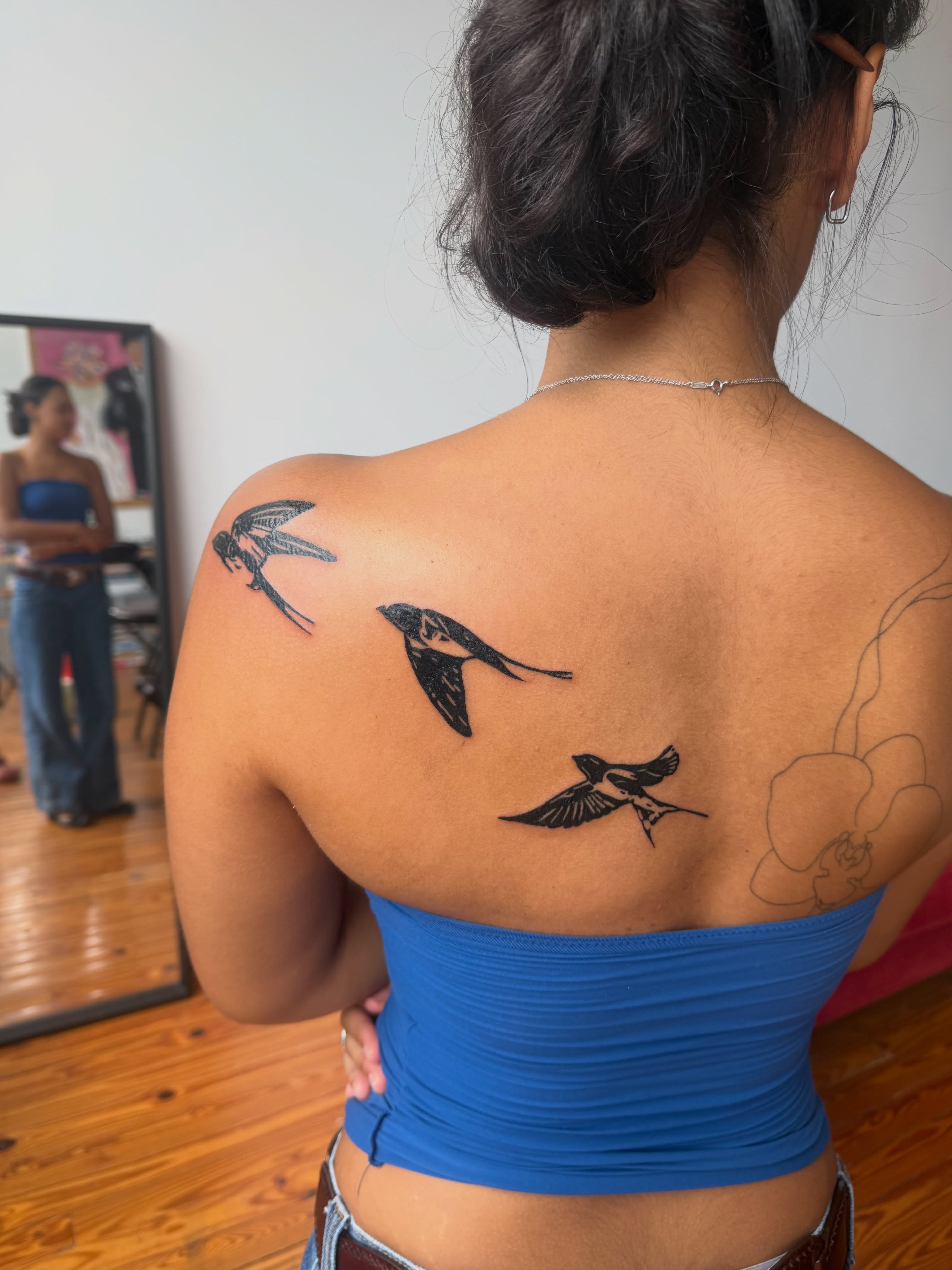 Swallows black and grey tattoo on the back by Jose Javier