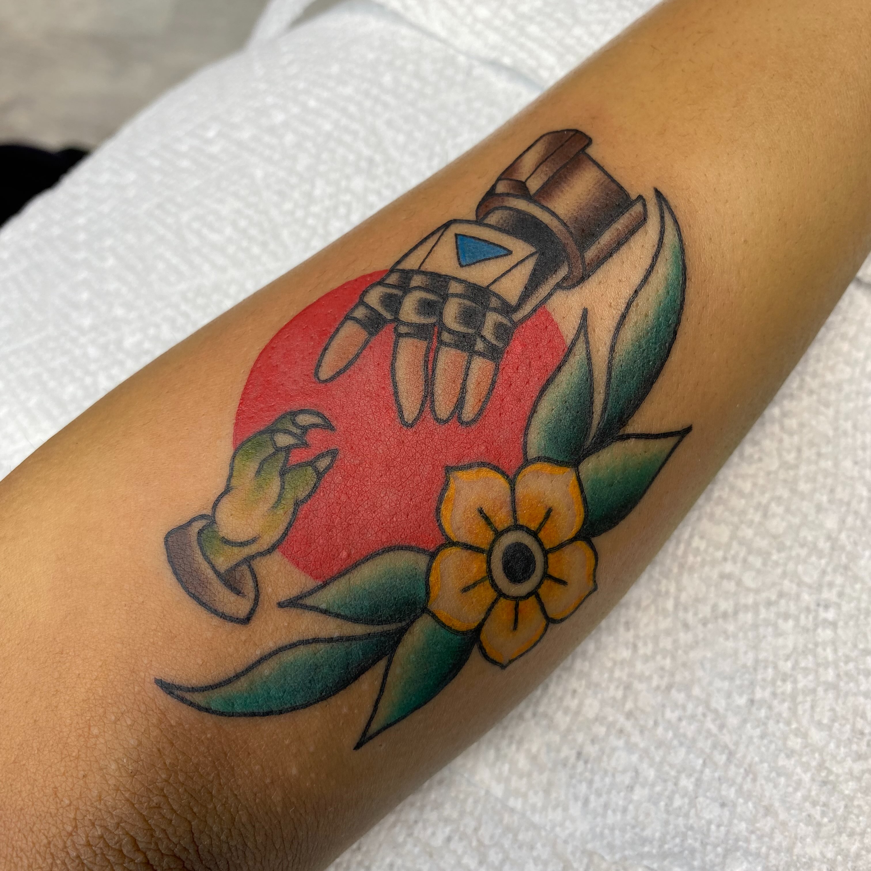 Robot hand and flower American traditional tattoo on the forearm by Jarid Penn