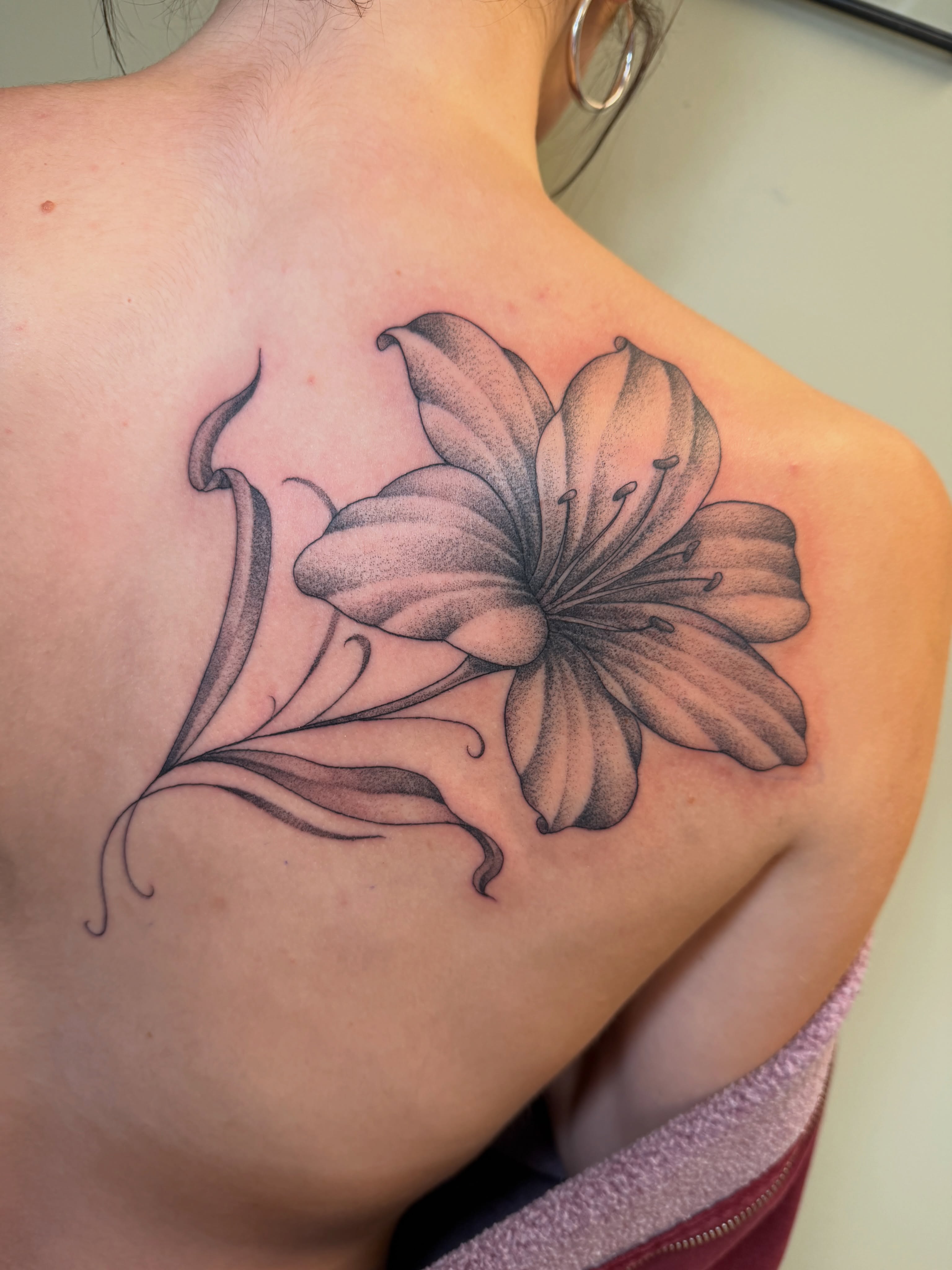 Lily black and grey tattoo on the shoulder by Koryn Donnelly
