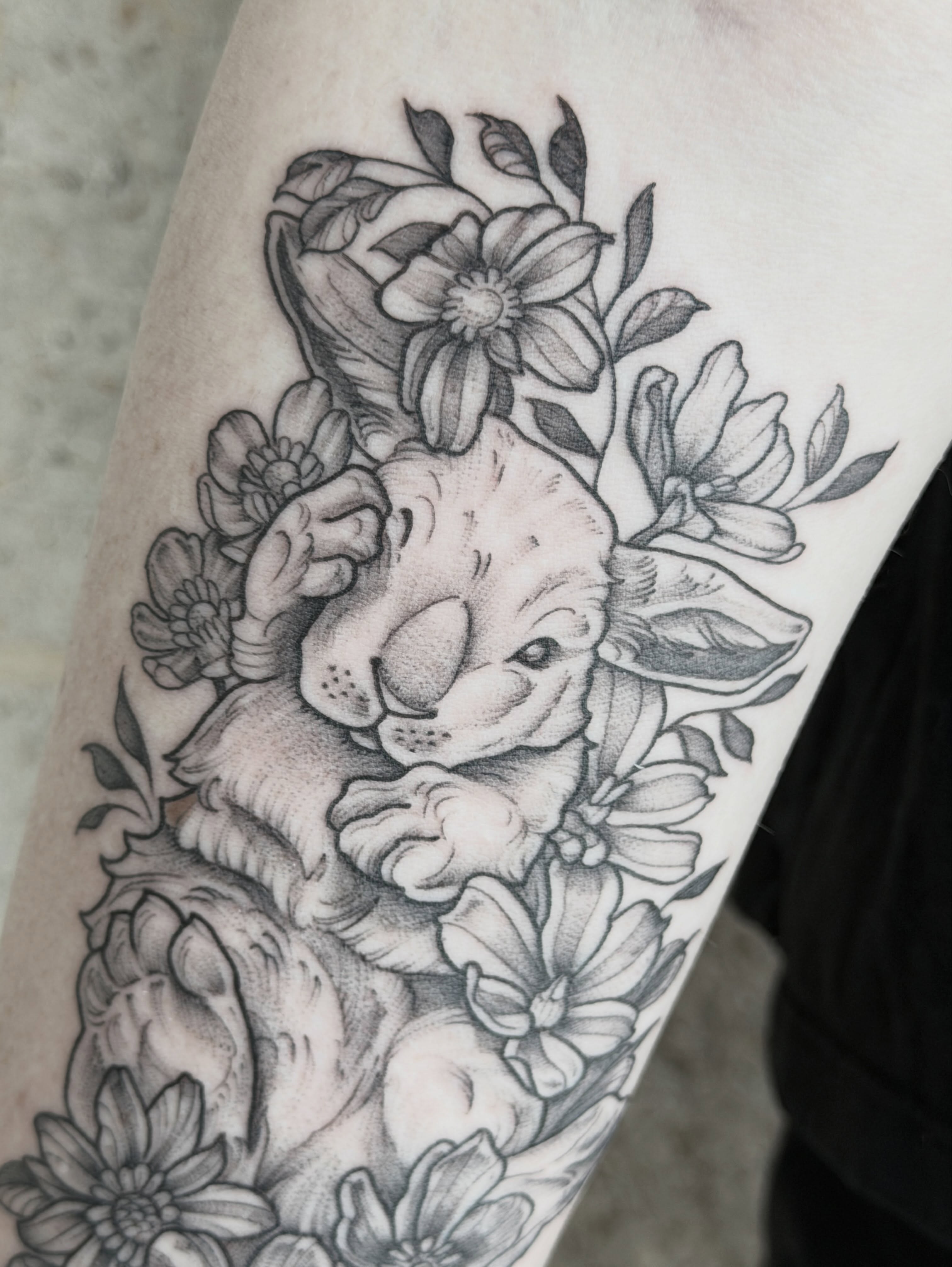 Sleeping rabbit surrounded by flowers realism tattoo on the forearm by Kirsten Marsden Ballantyne
