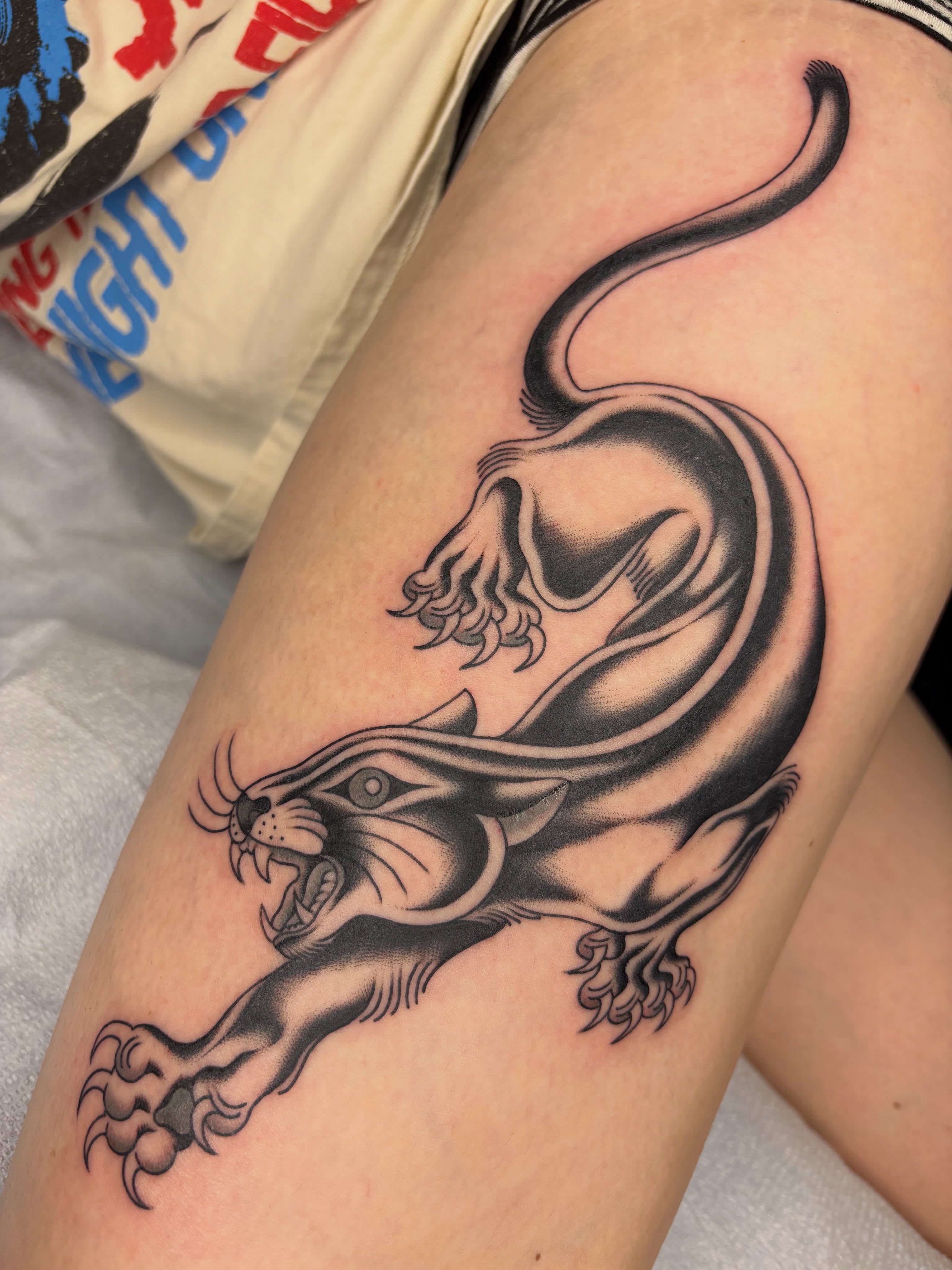 Panther black and grey tattoo on the thigh by Nori