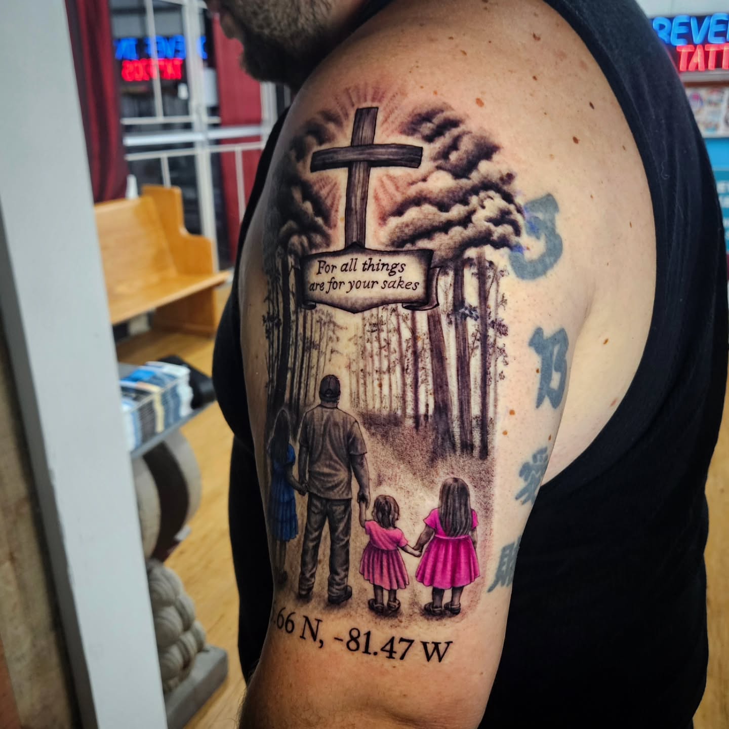 Family scene with cross realism tattoo on the shoulder by Isaac Morales