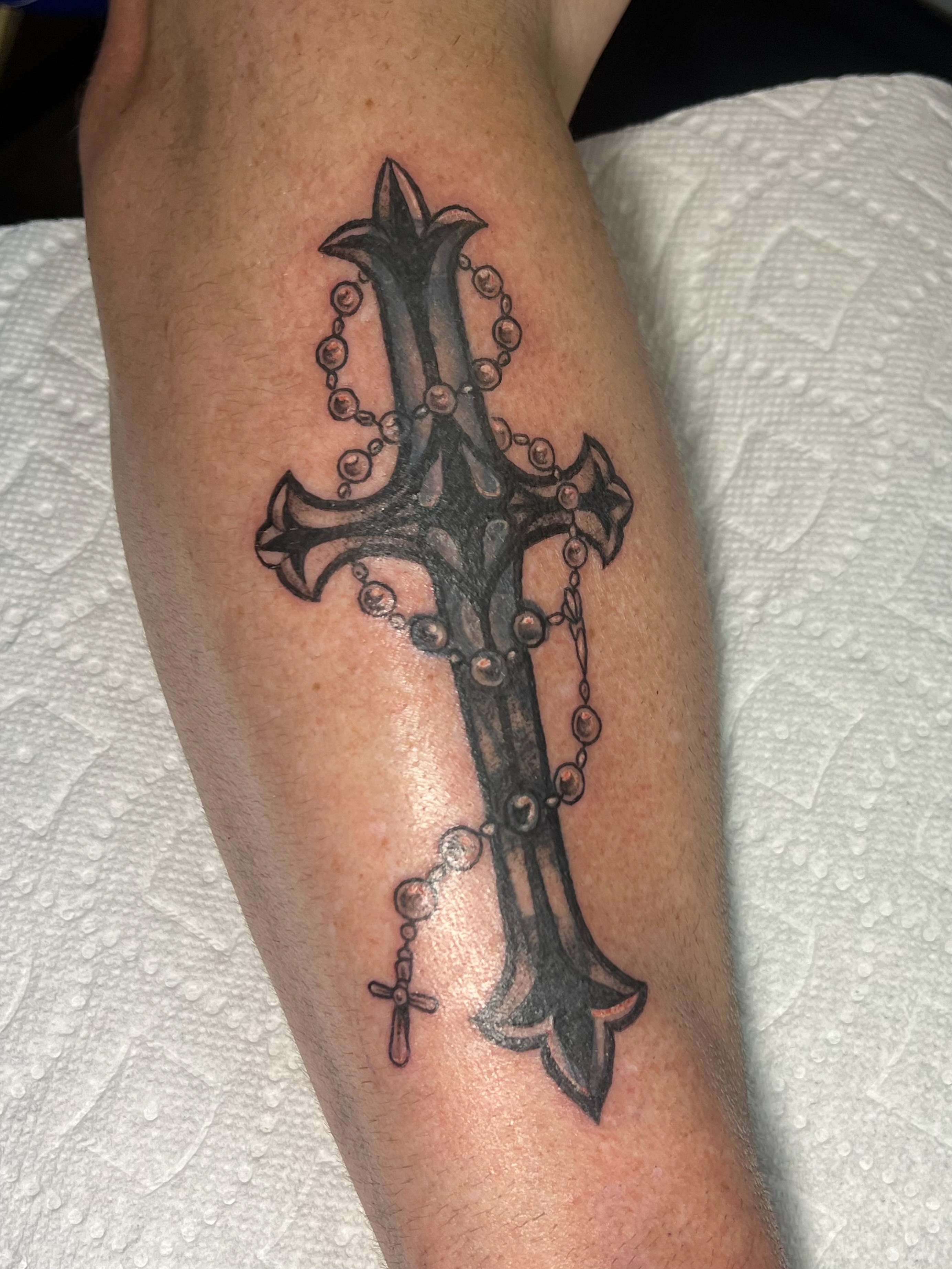 Cross with rosary black and grey tattoo on the forearm by ꧁ 𝓛𝖎𝖛 ꧂, Cambridge, Massachusetts