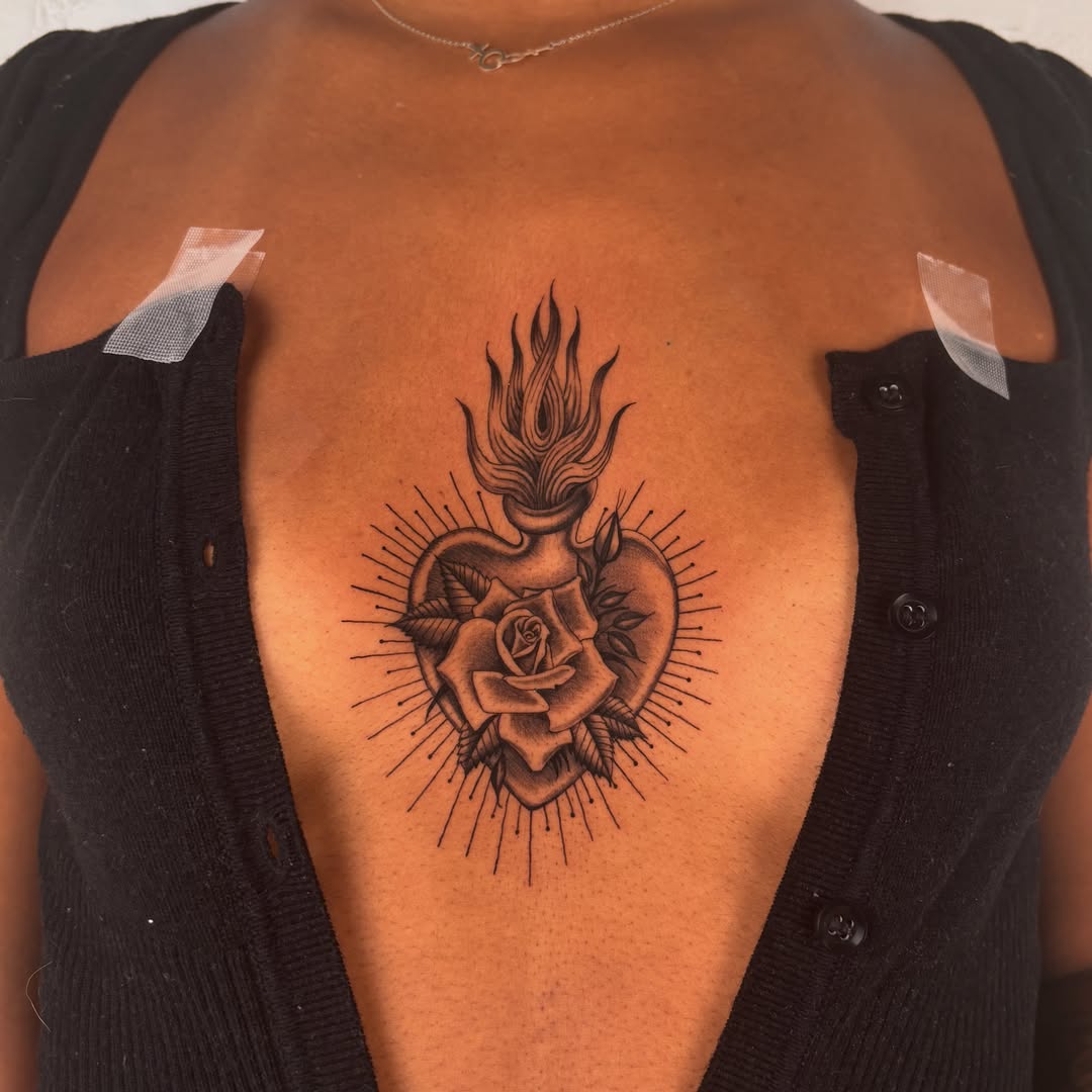 Heart with rose American traditional tattoo on the chest by laura bianca