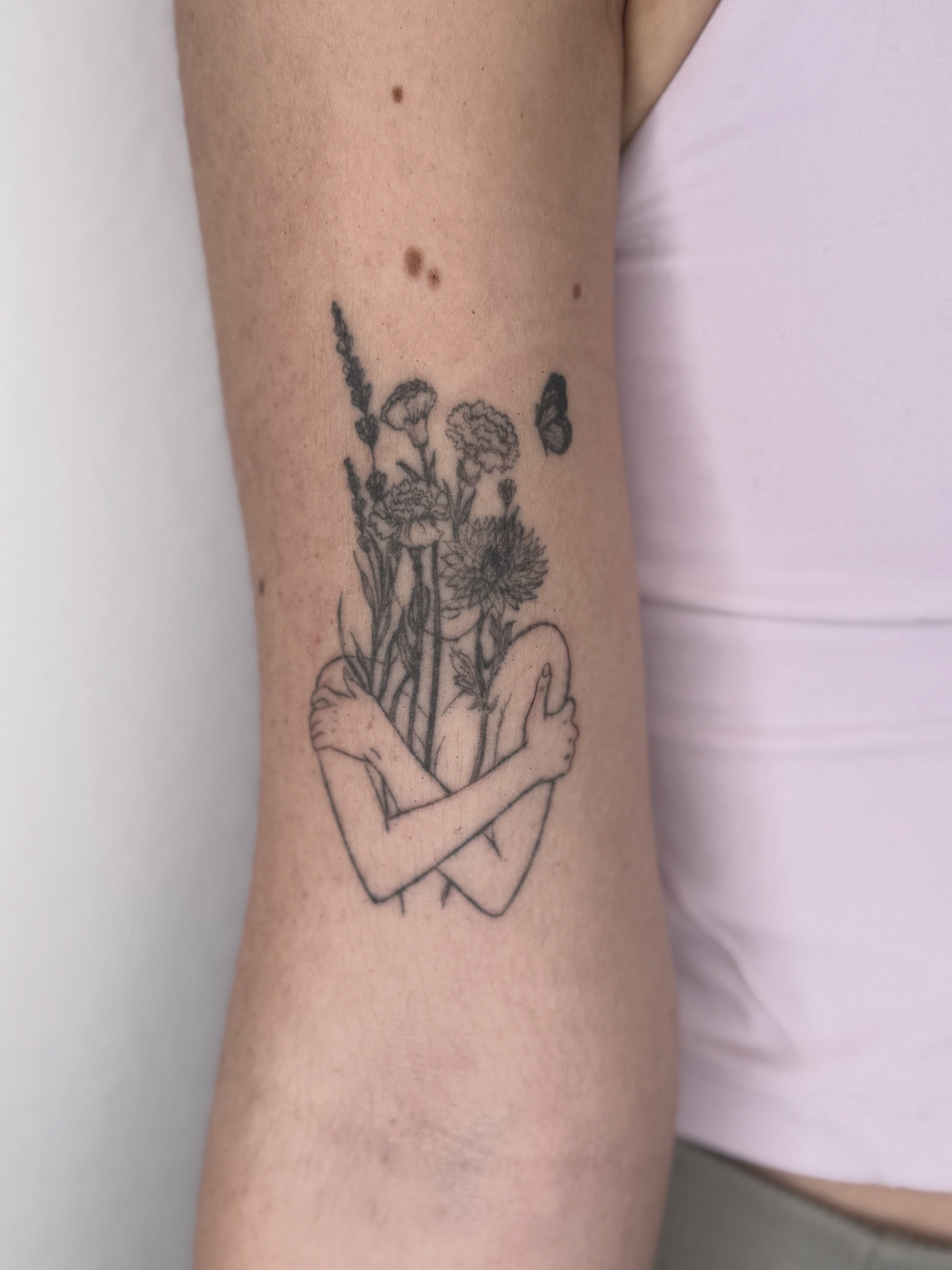 Wildflowers and arms black and grey tattoo on the forearm by Ashley Limon
