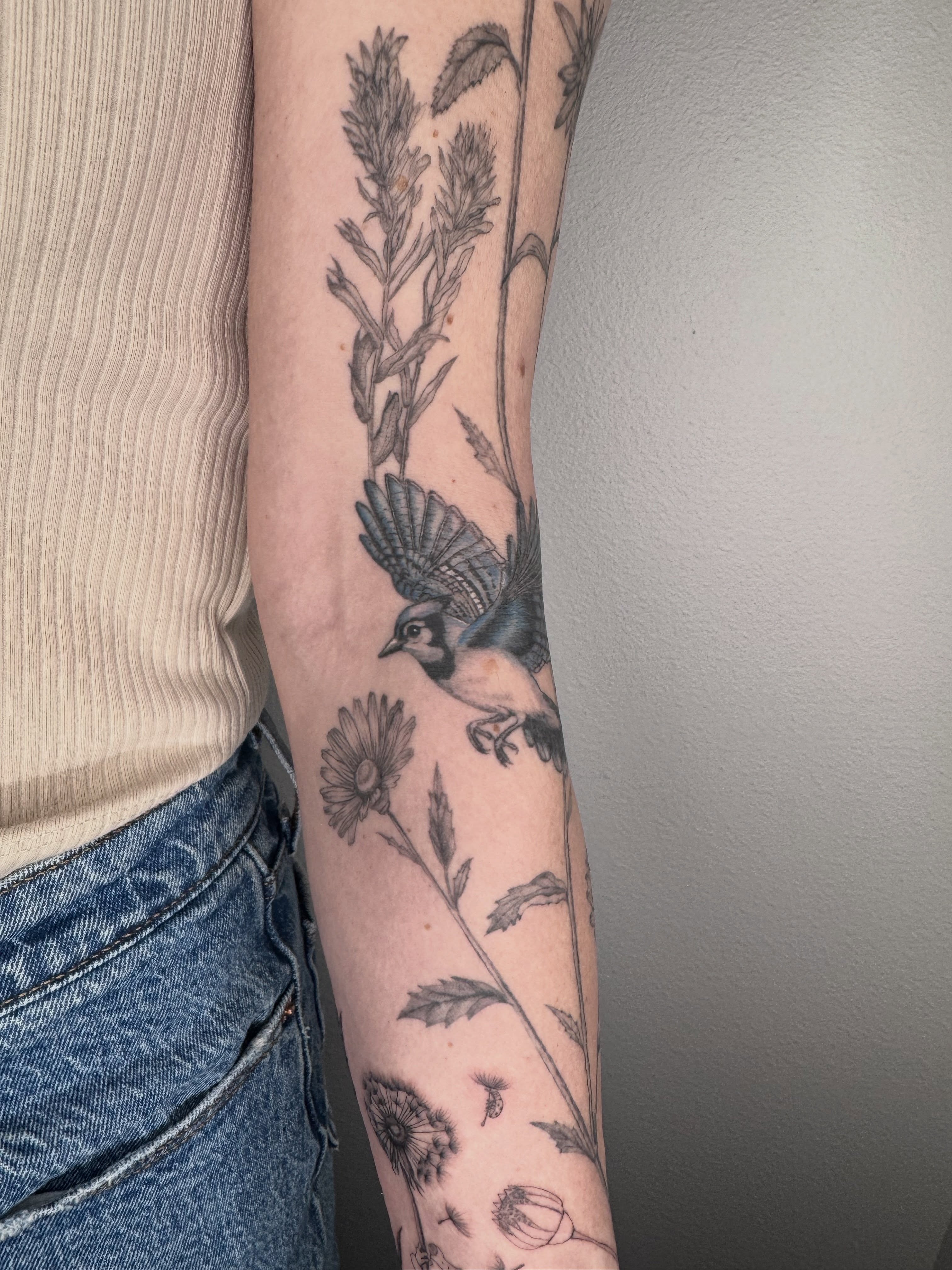 Bird and floral realism tattoo on the forearm by Ashley Limon