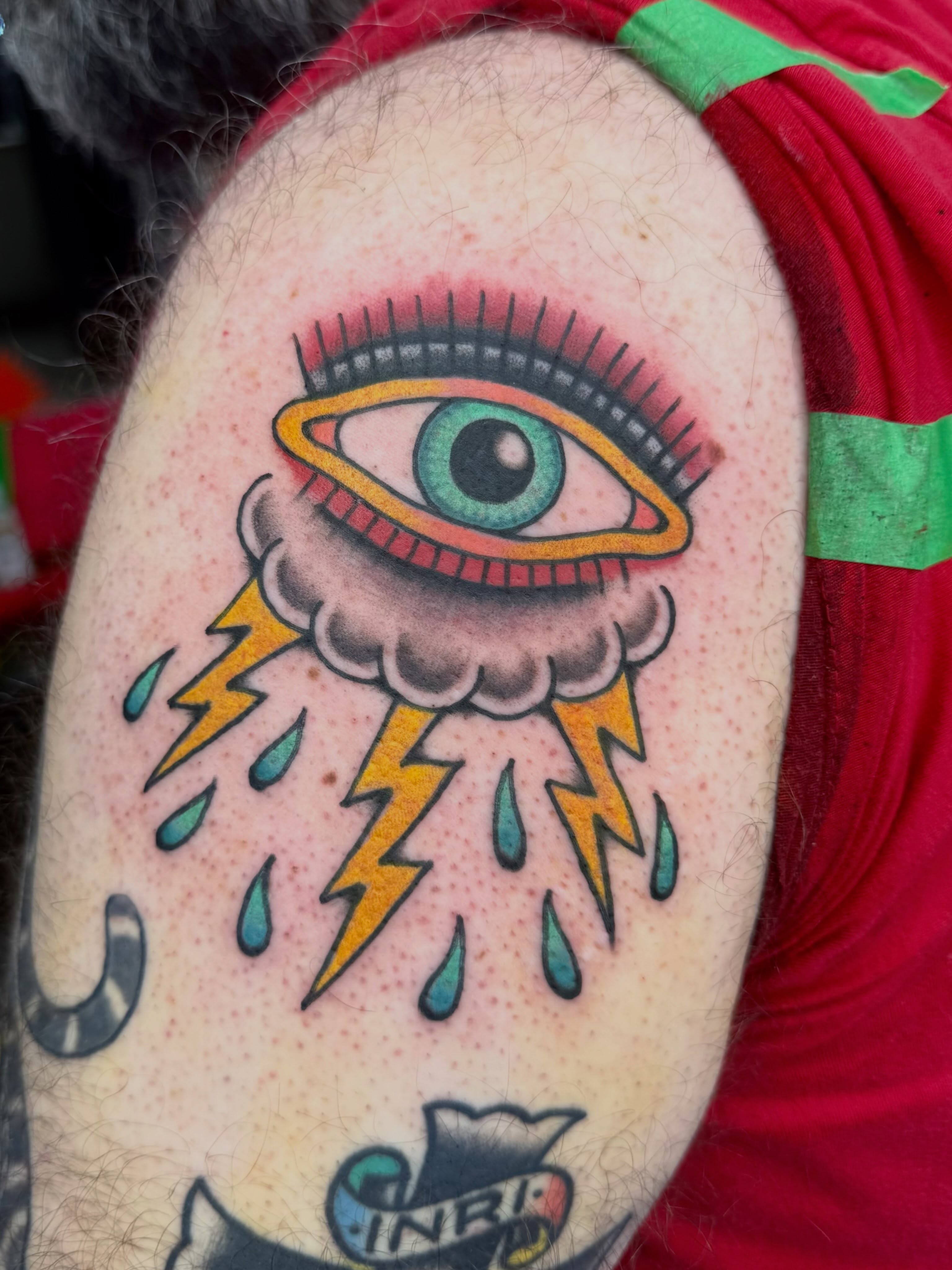 Eye with cloud and lightning American traditional tattoo on the shoulder by Sarah Christine Tattoo, Calgary, Alberta