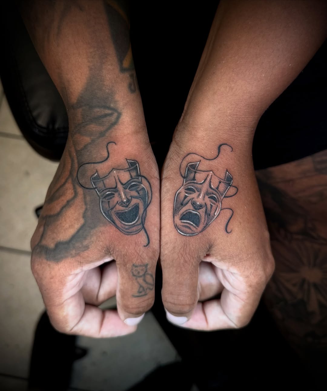 Theater masks black and grey tattoo on the hand by Stilow Memphis Tattoo Artist, Memphis, Tennessee