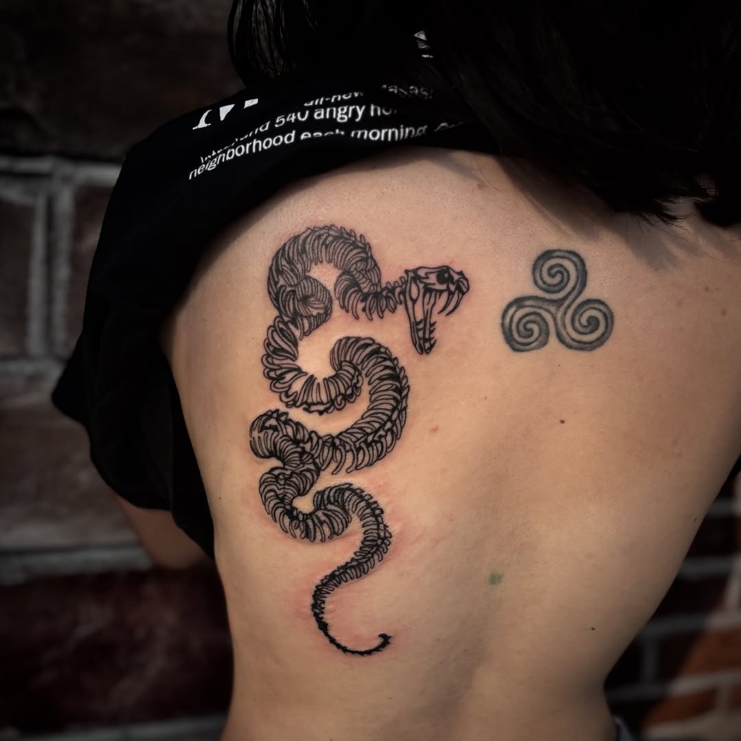 Snake and triskele black and grey tattoo on the back by π΅πππππ