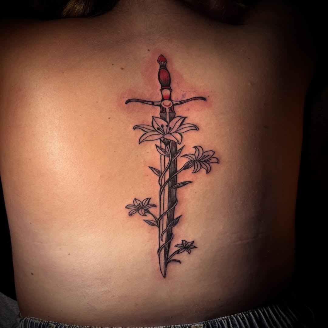 Sword and flowers black and grey tattoo on the back by π΅πππππ