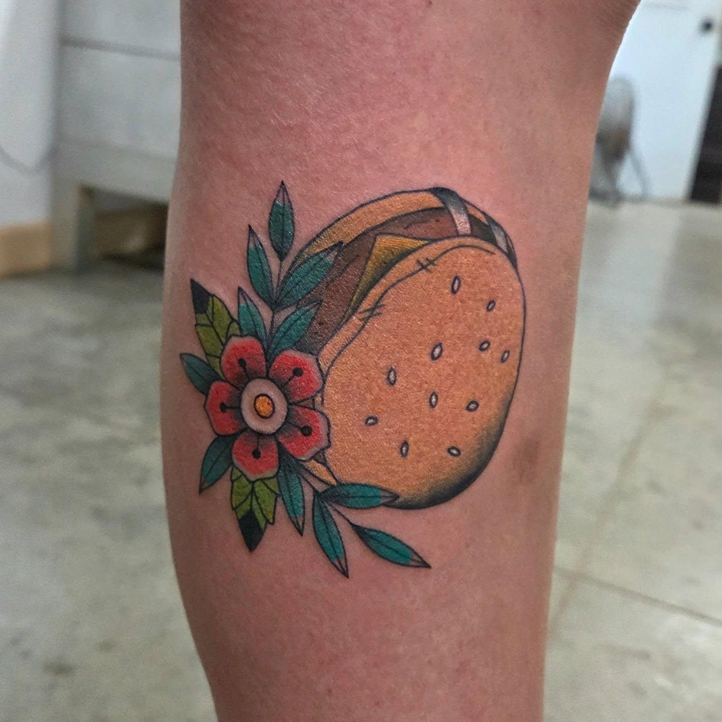 Hamburger and flower American traditional tattoo on the forearm by Ashley