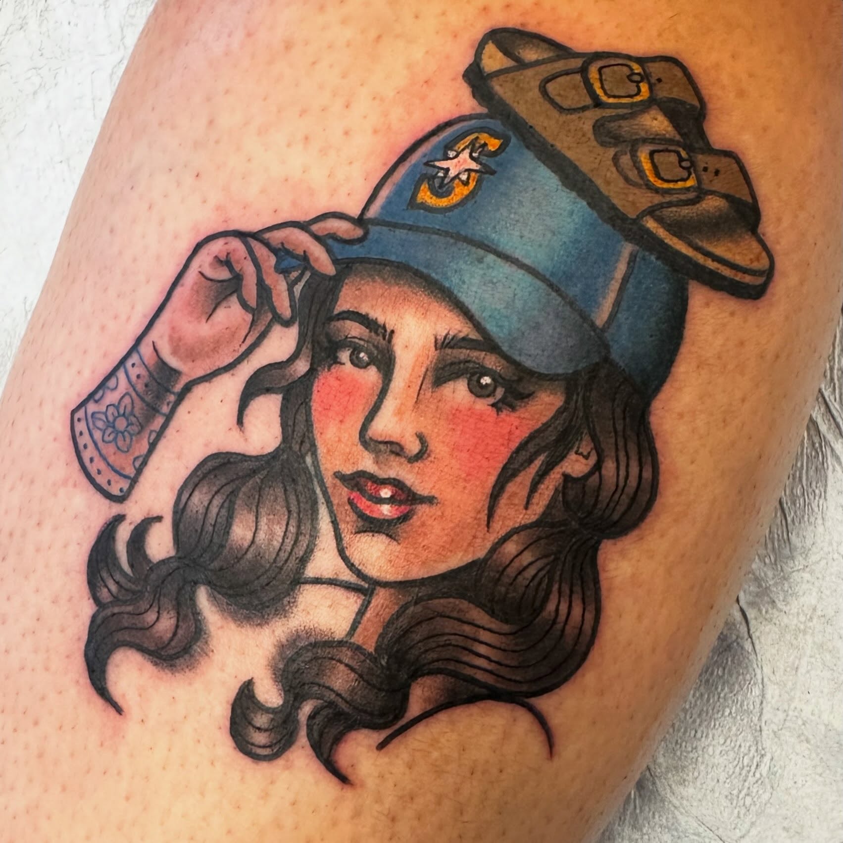 Woman wearing hat American traditional tattoo on the thigh by Katie Beth