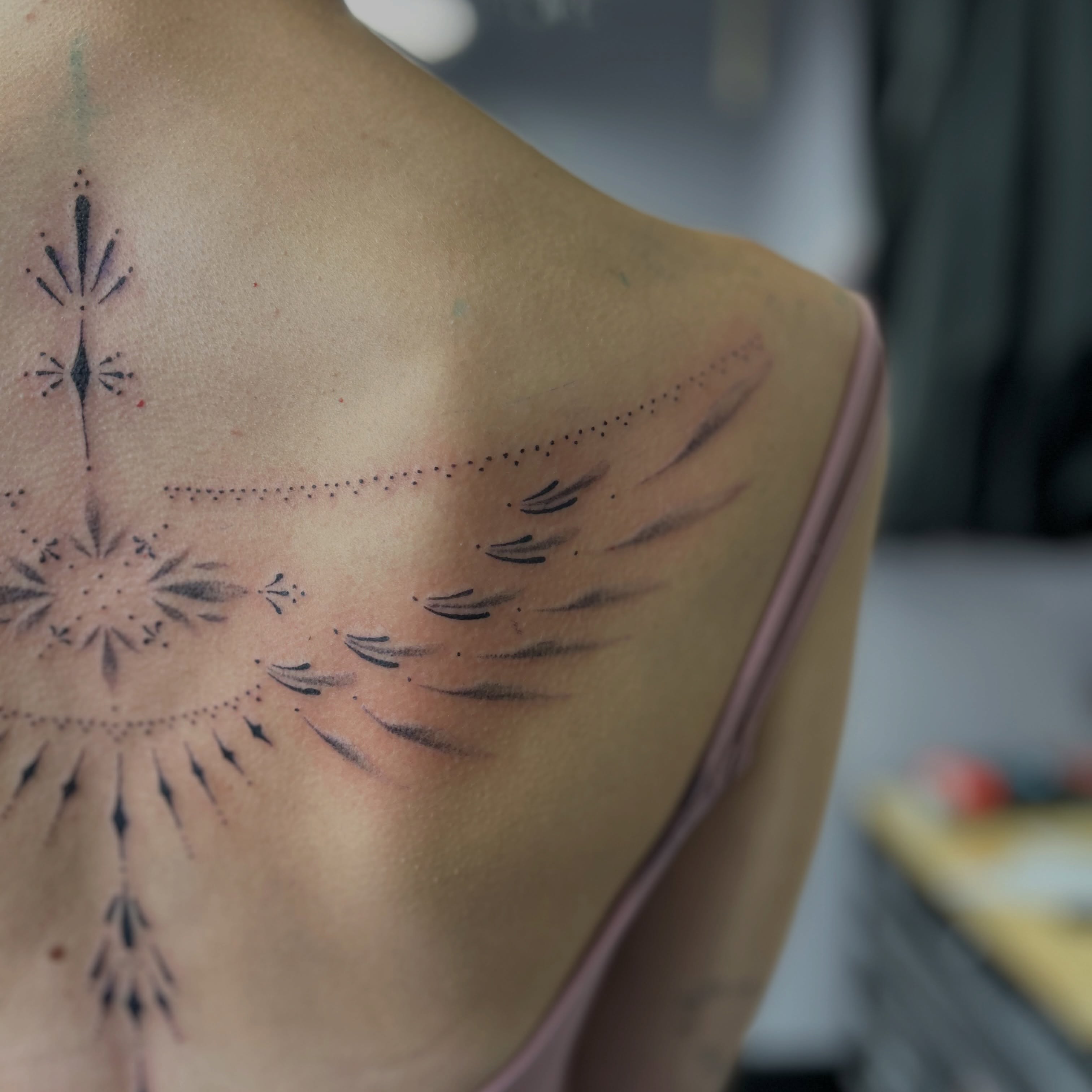 Feather and geometric pattern dotwork tattoo on the shoulder by Natalie Johnson, Minneapolis, Minnesota