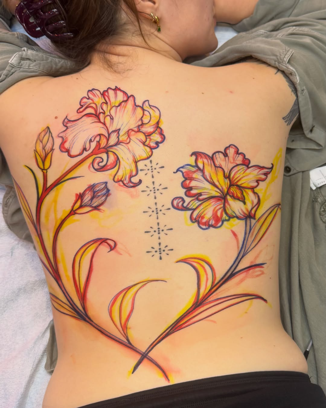 Flowers watercolor tattoo on the back by Makayla Dupre