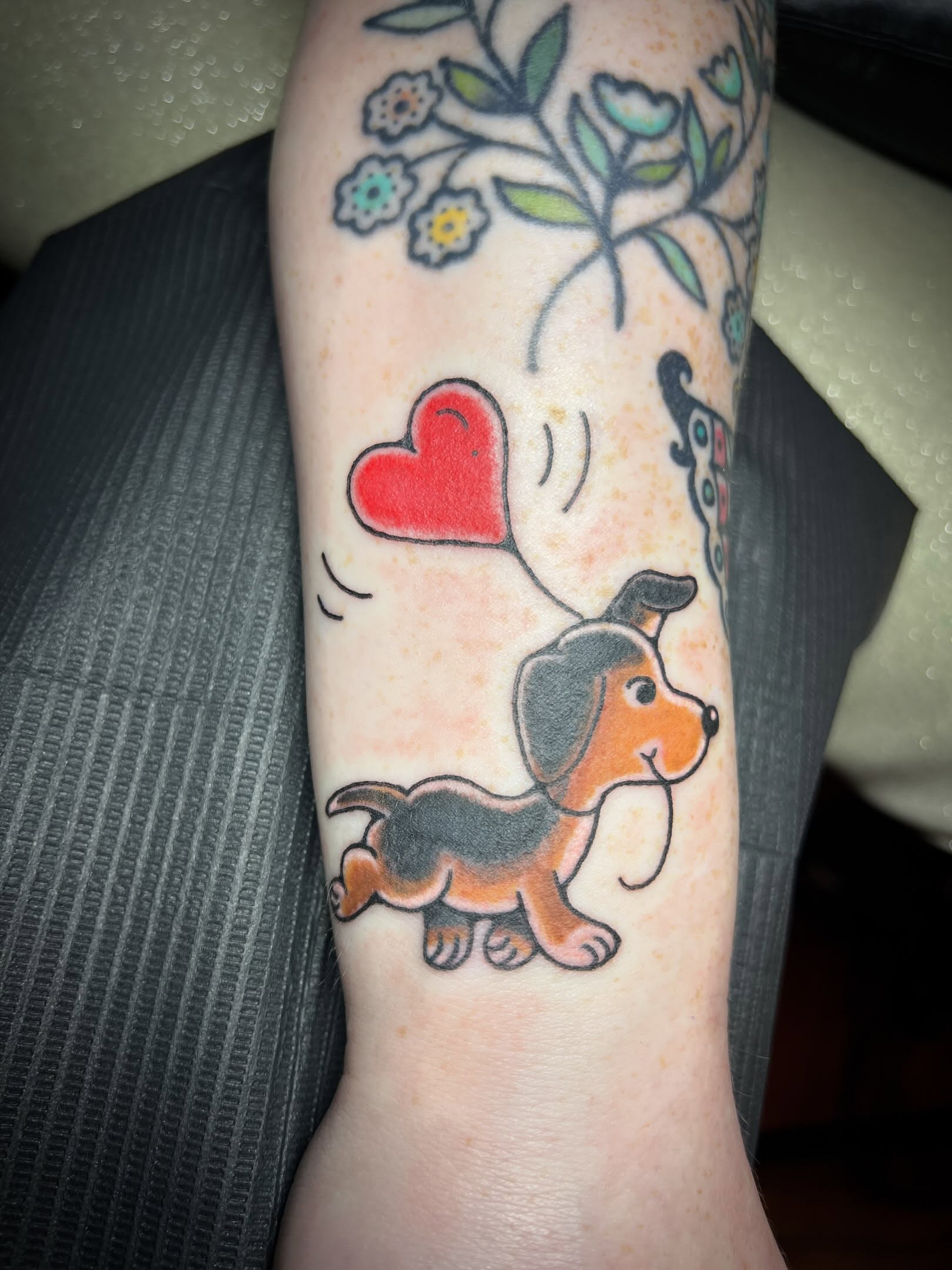 Dog with heart balloon new school tattoo on the forearm by Tattoo Kayla