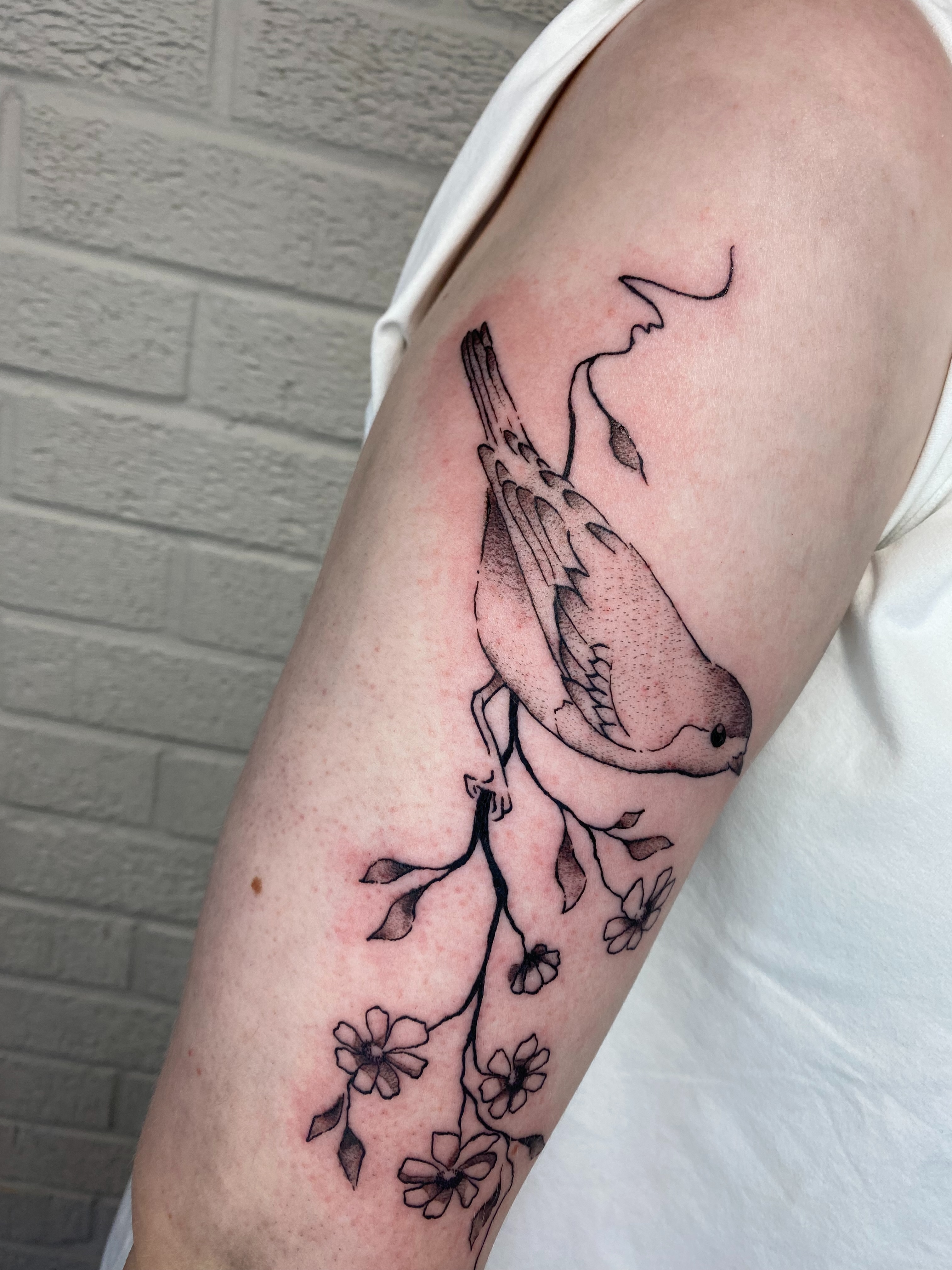 Bird and blossoms black and grey tattoo on the forearm by Ellena Reggiani