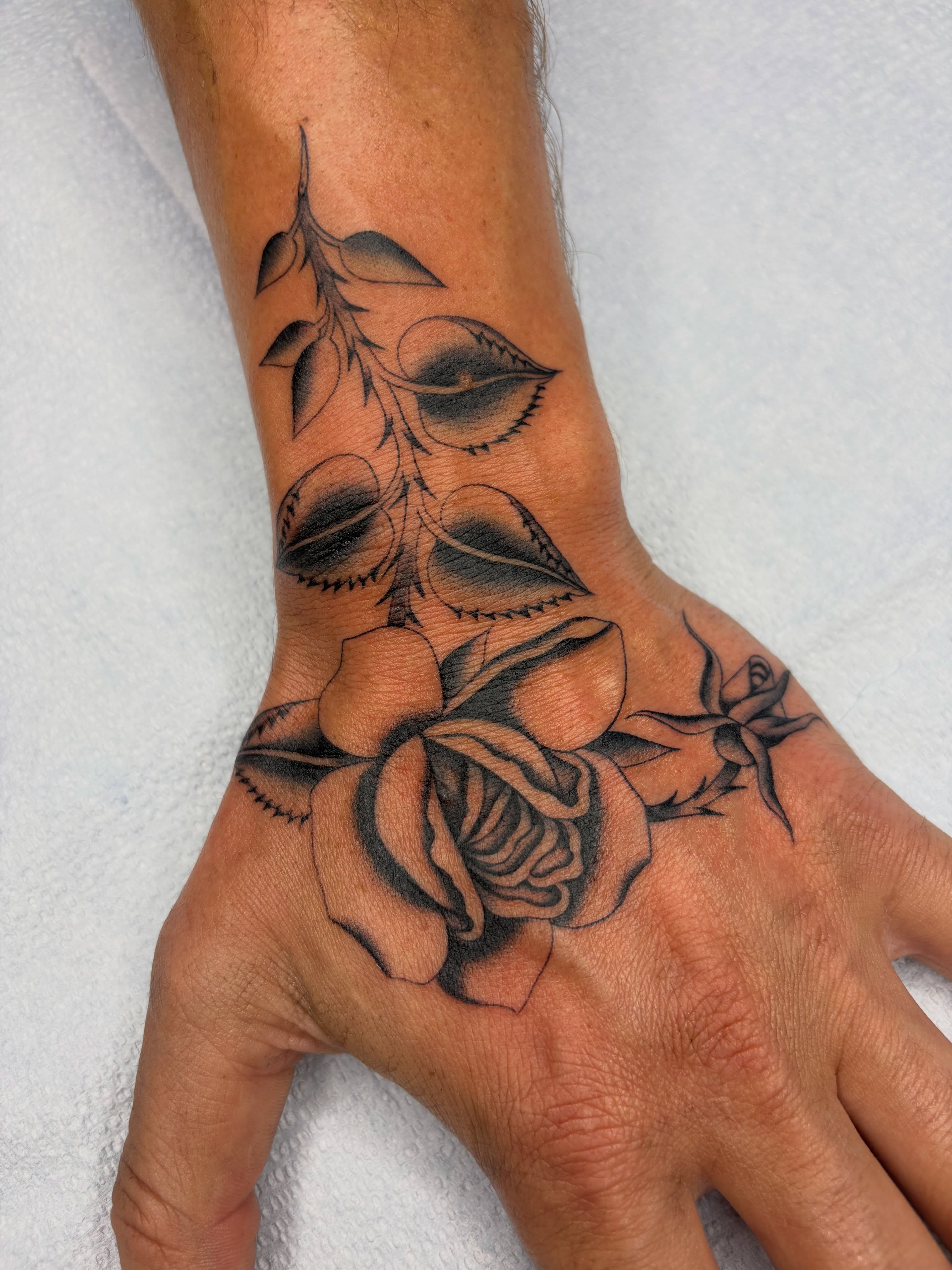 Rose black and grey tattoo on the hand by Nori