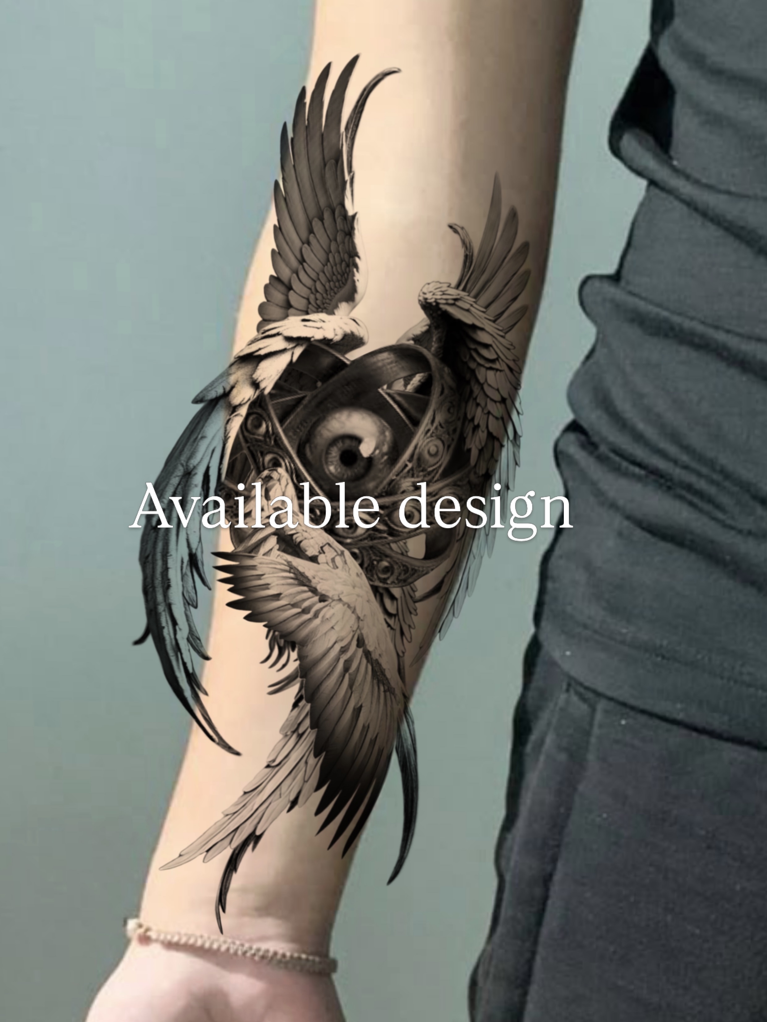 Wings and eye black and grey tattoo on the forearm by AMU
