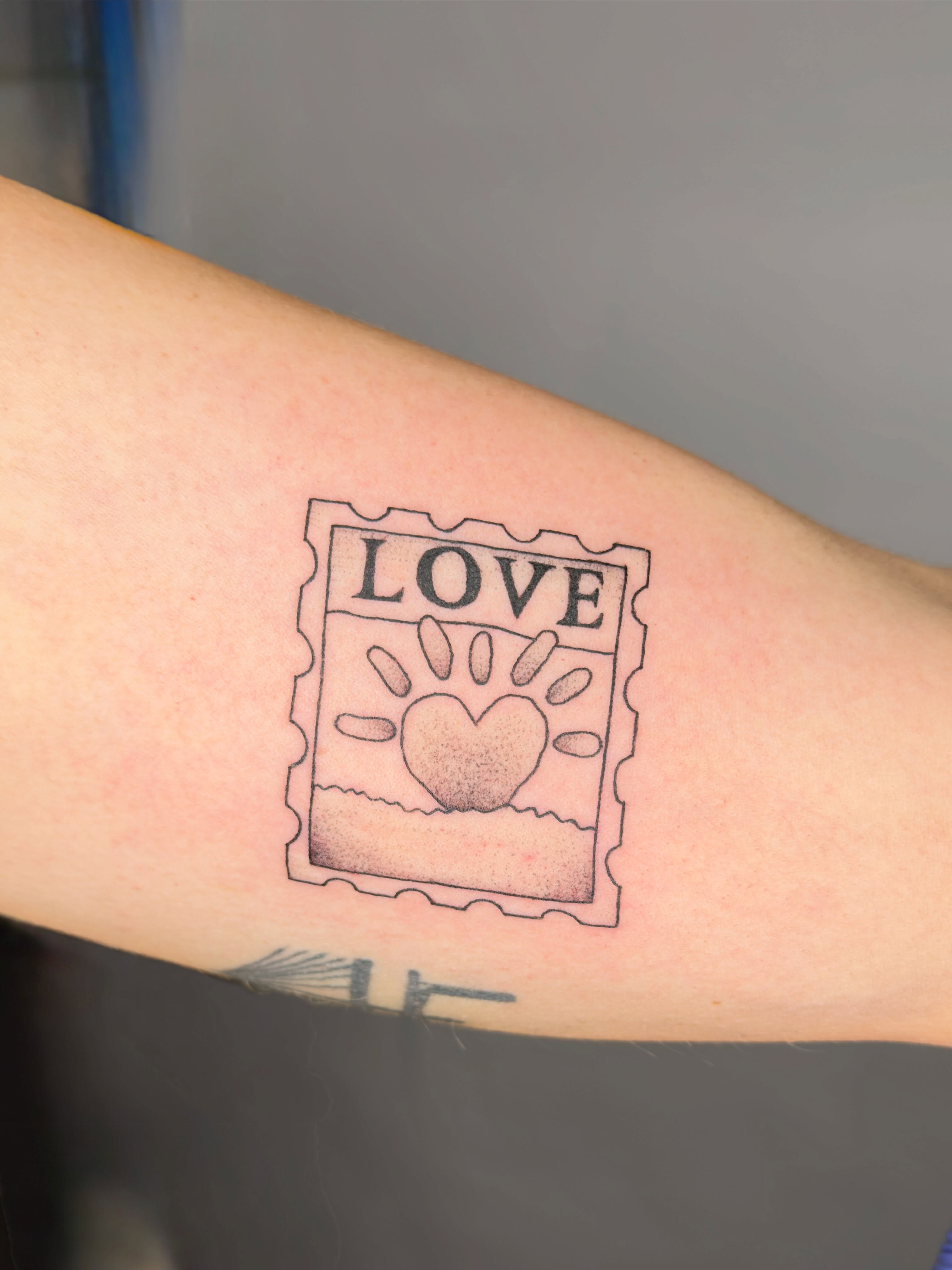 Love stamp dotwork tattoo on the forearm by Charlotte (Luna), Seattle, Washington