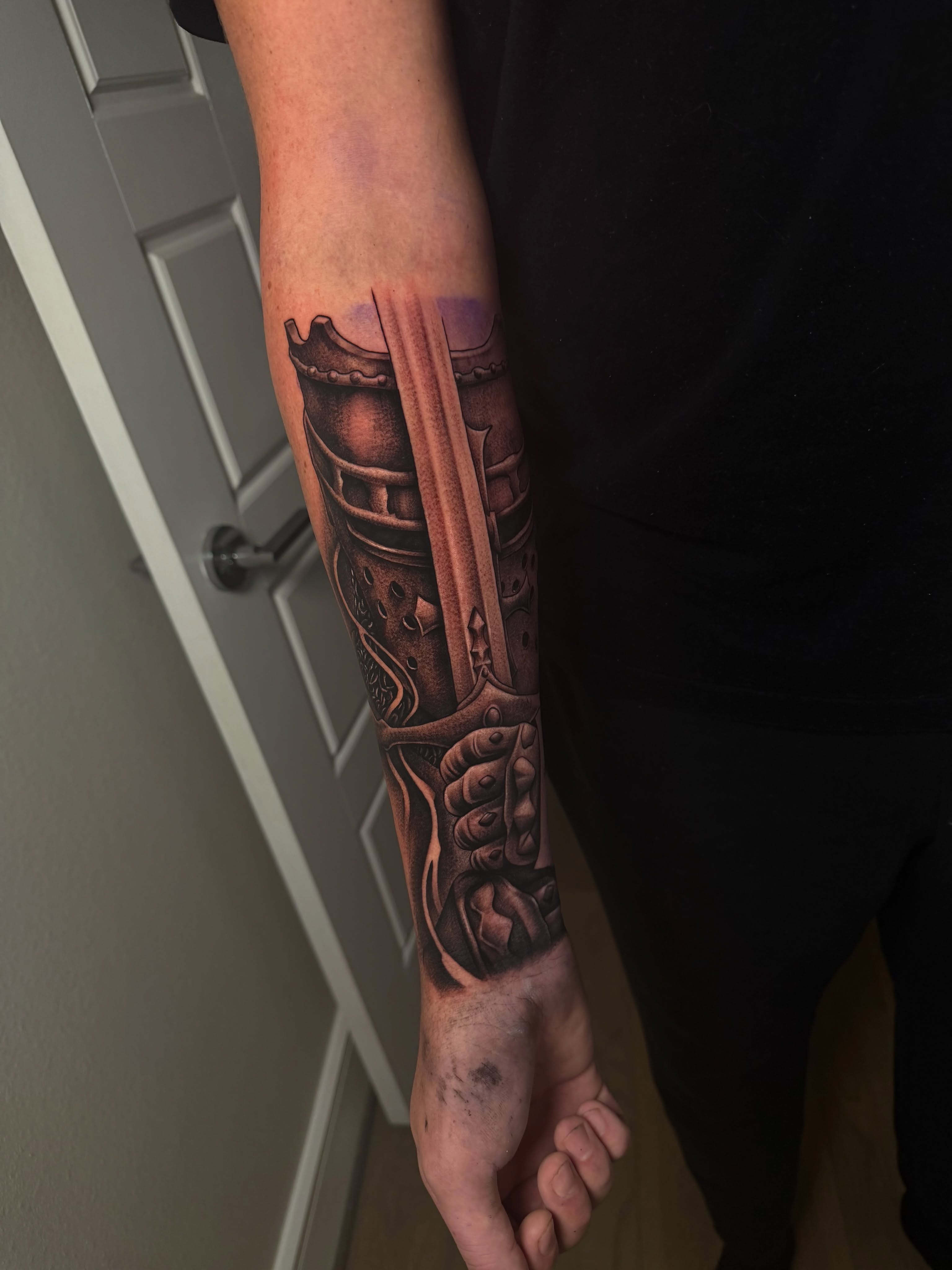 Sword and armor realism tattoo on the forearm by Josh Acosta