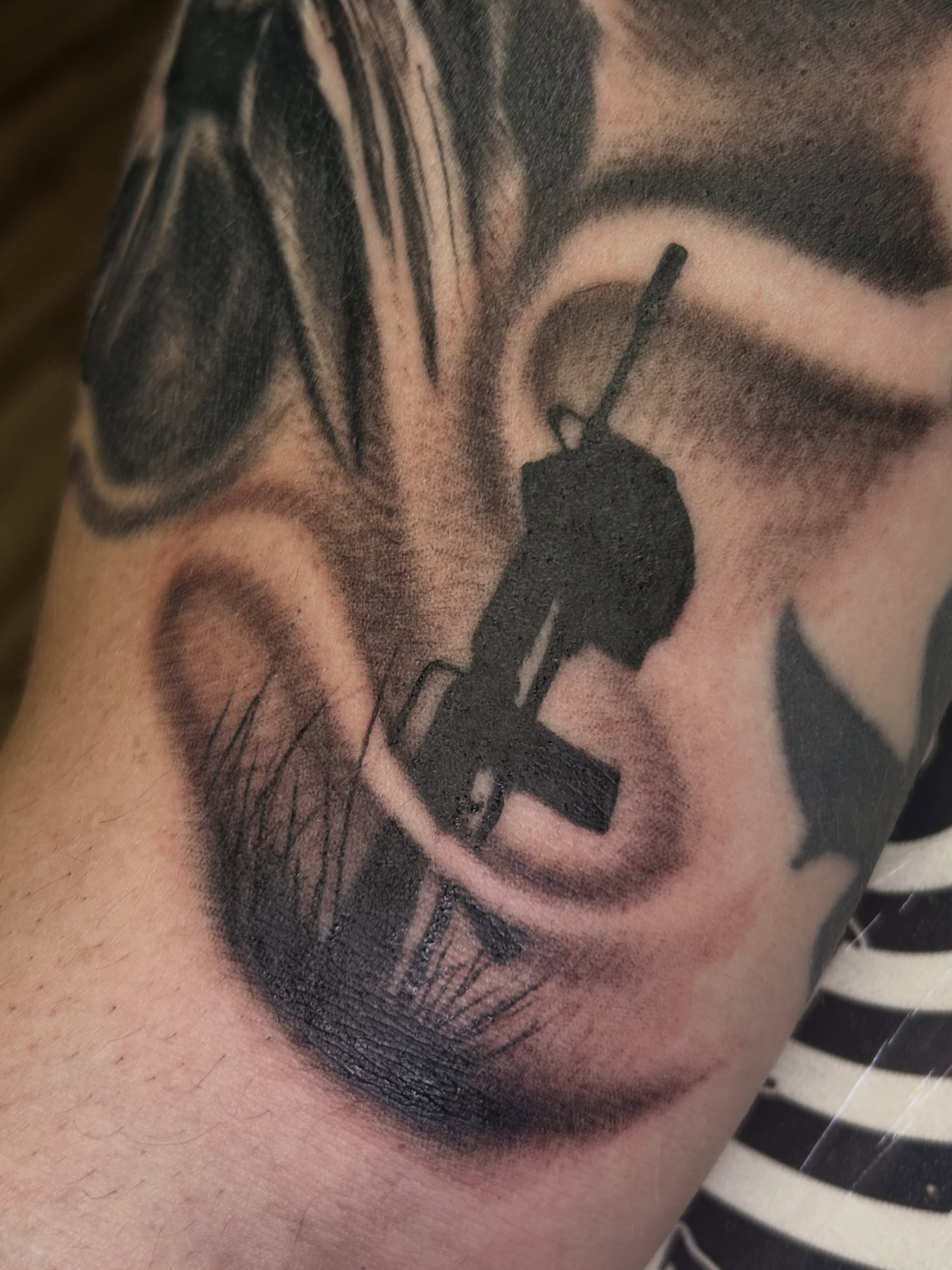 Gun silhouette black and grey tattoo on the forearm by Dan Schuster