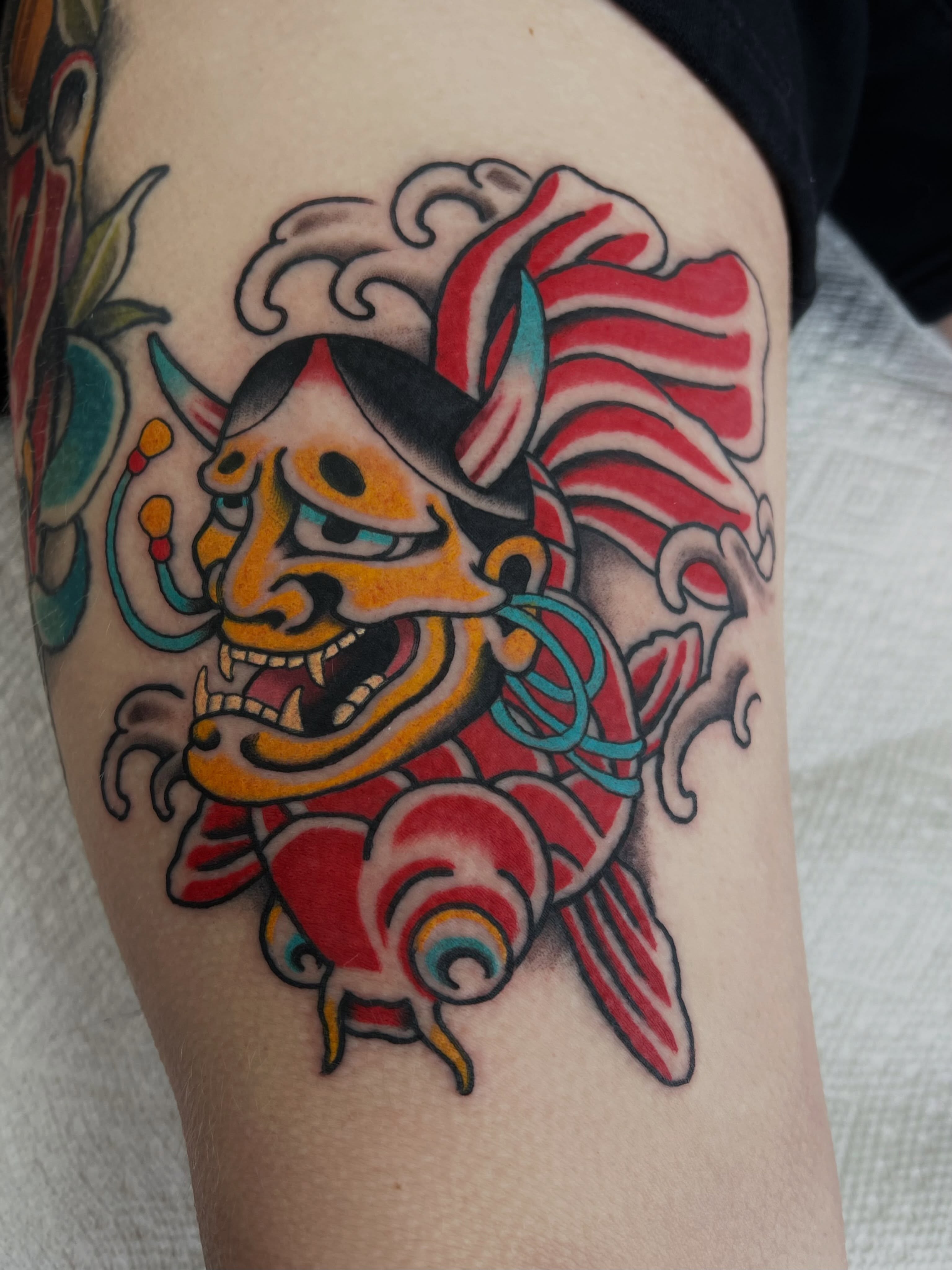 Oni mask American traditional tattoo on the thigh by Brandon McDaniel Iowa Tattoo Artist