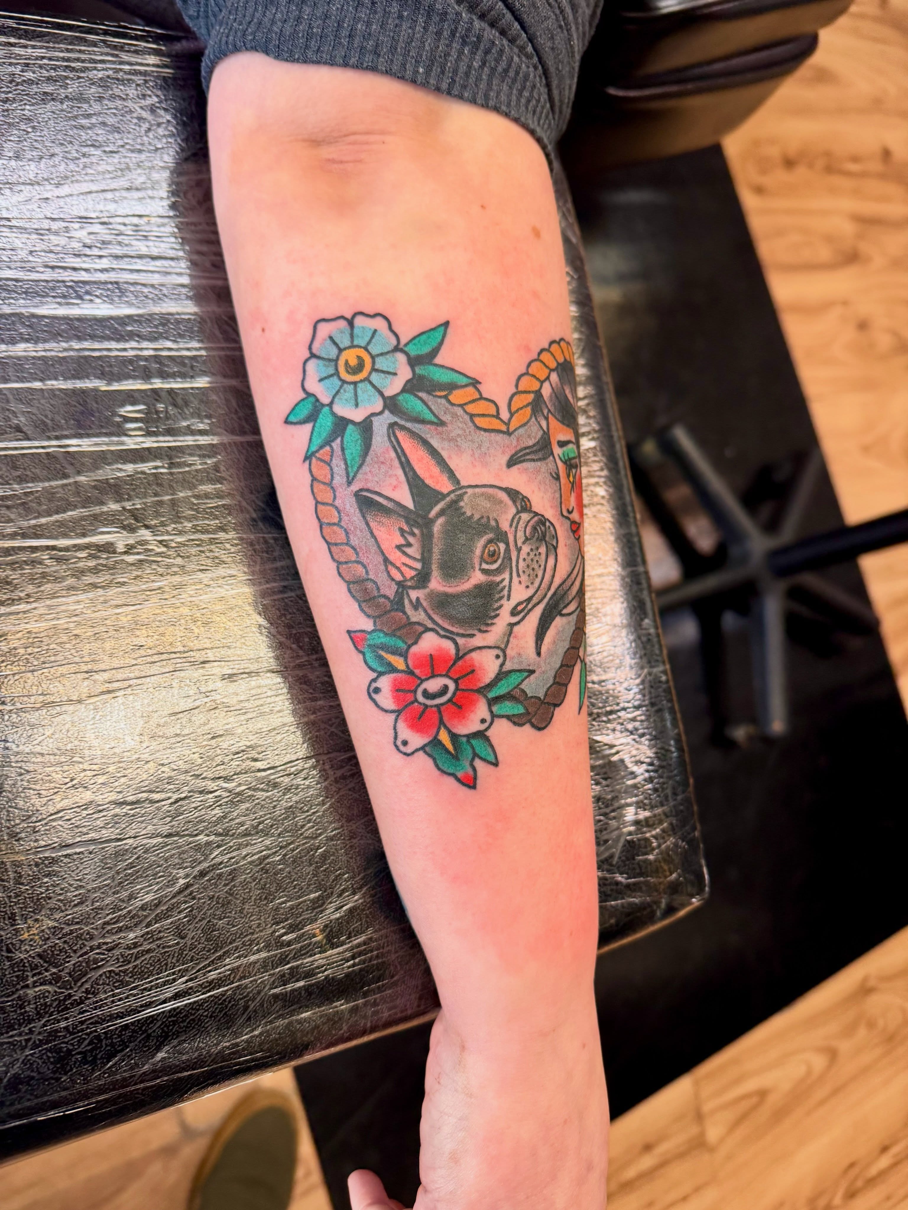 Dog with flowers American traditional tattoo on the forearm by Justin Chapman, Des Moines, Iowa