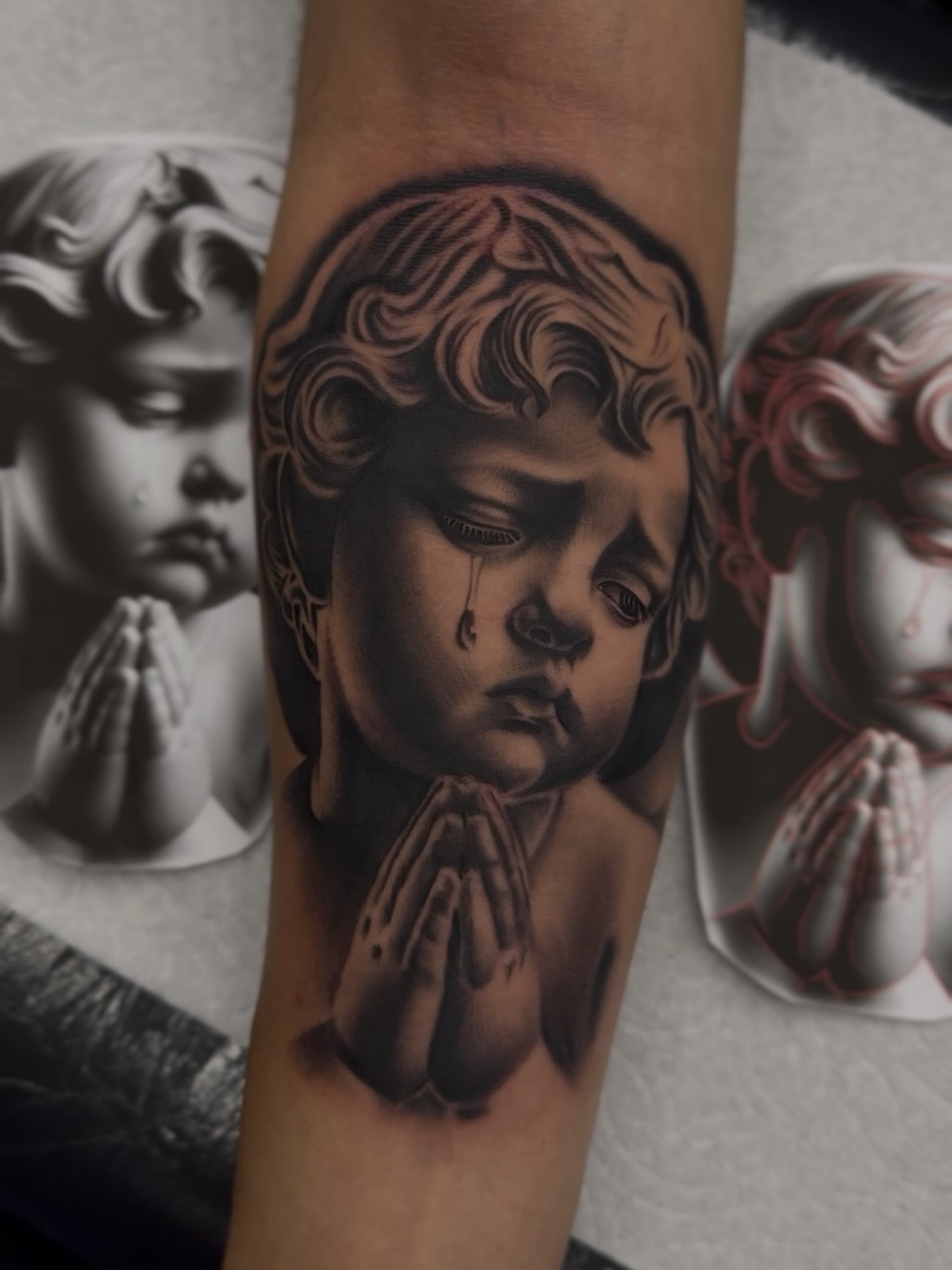 Child praying realism tattoo on the forearm by Alex Romero