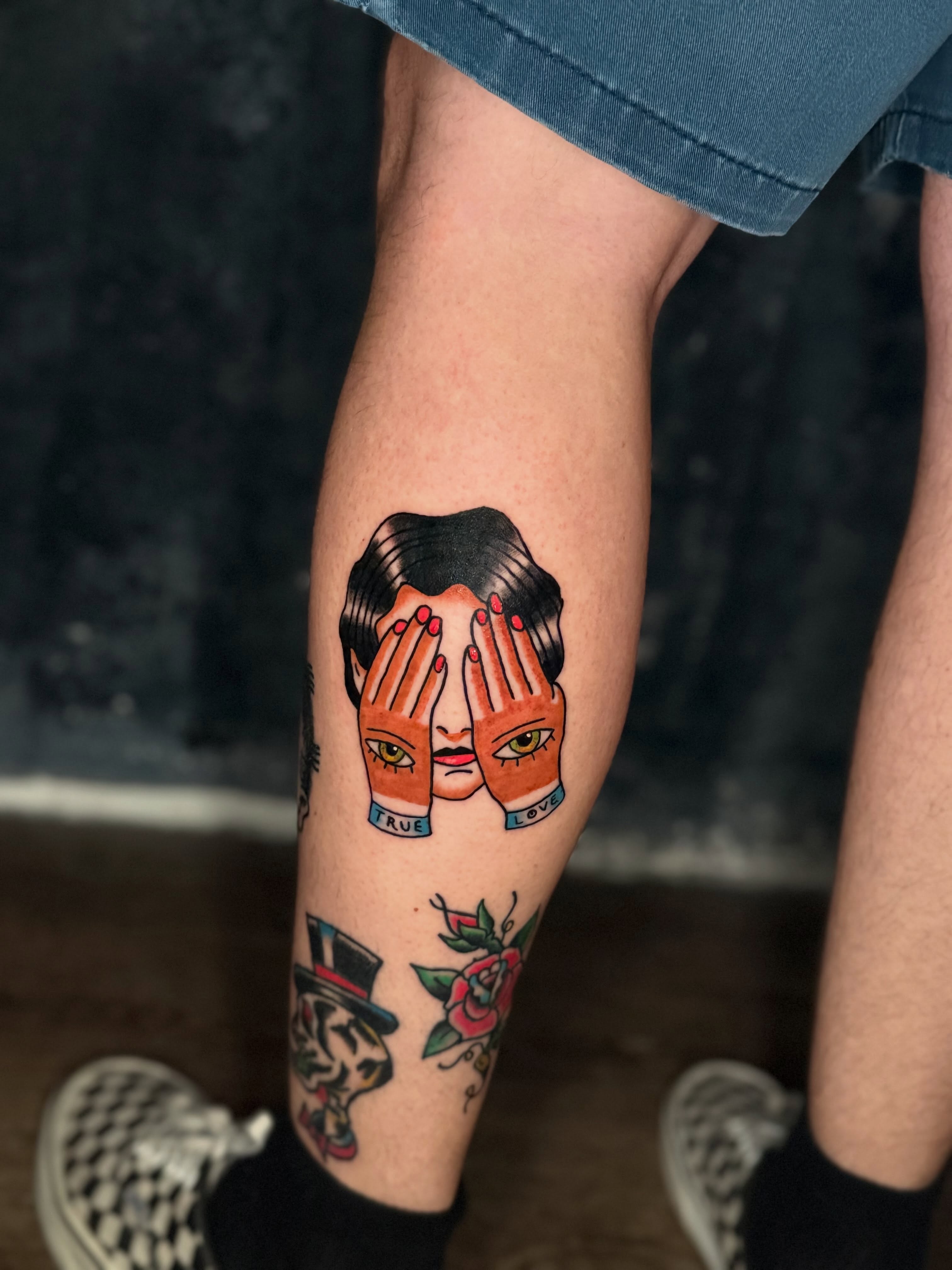 Hands covering face American traditional tattoo on the forearm by Camilo