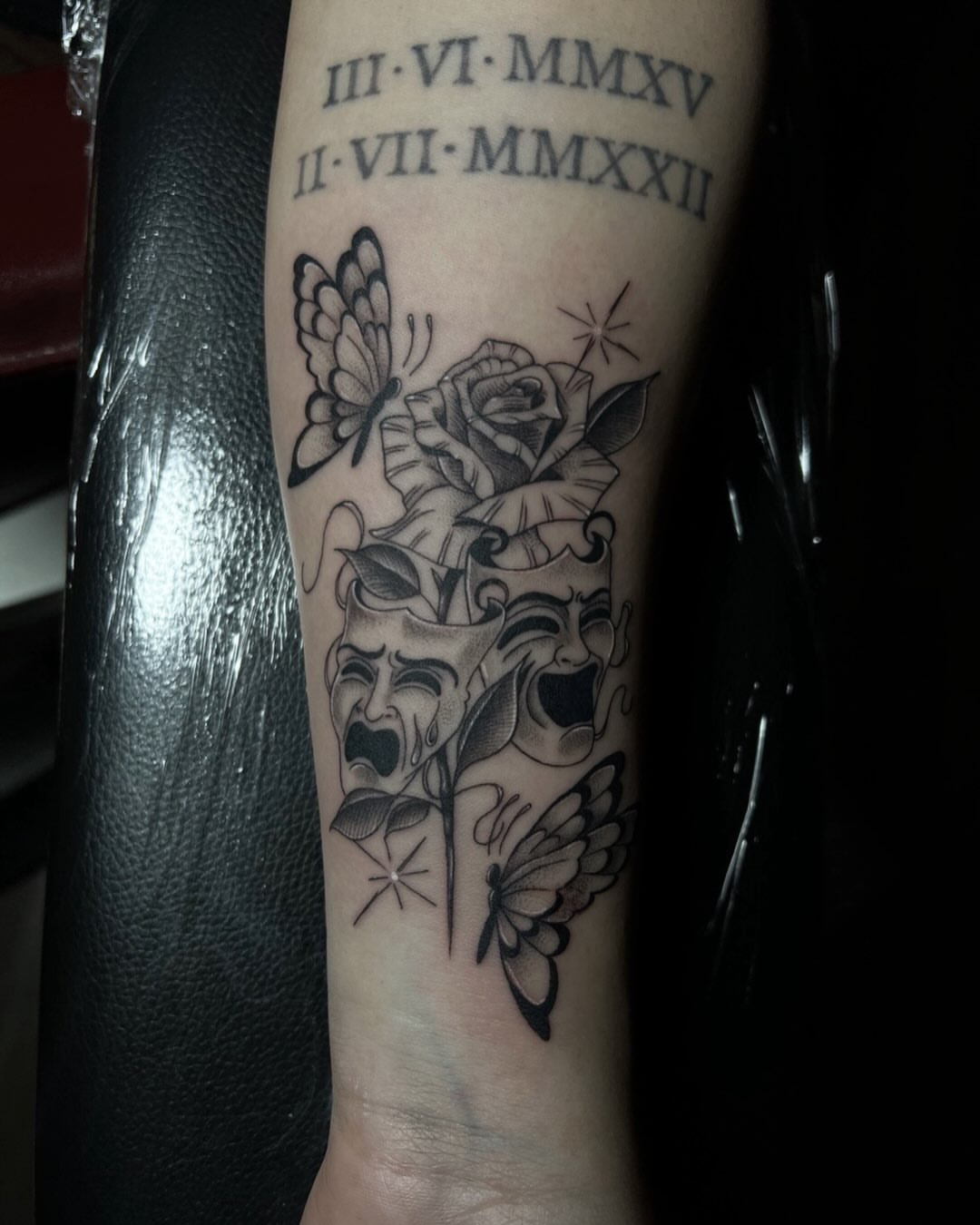 Theater masks and roses black and grey tattoo on the forearm by Iraymi Beltran