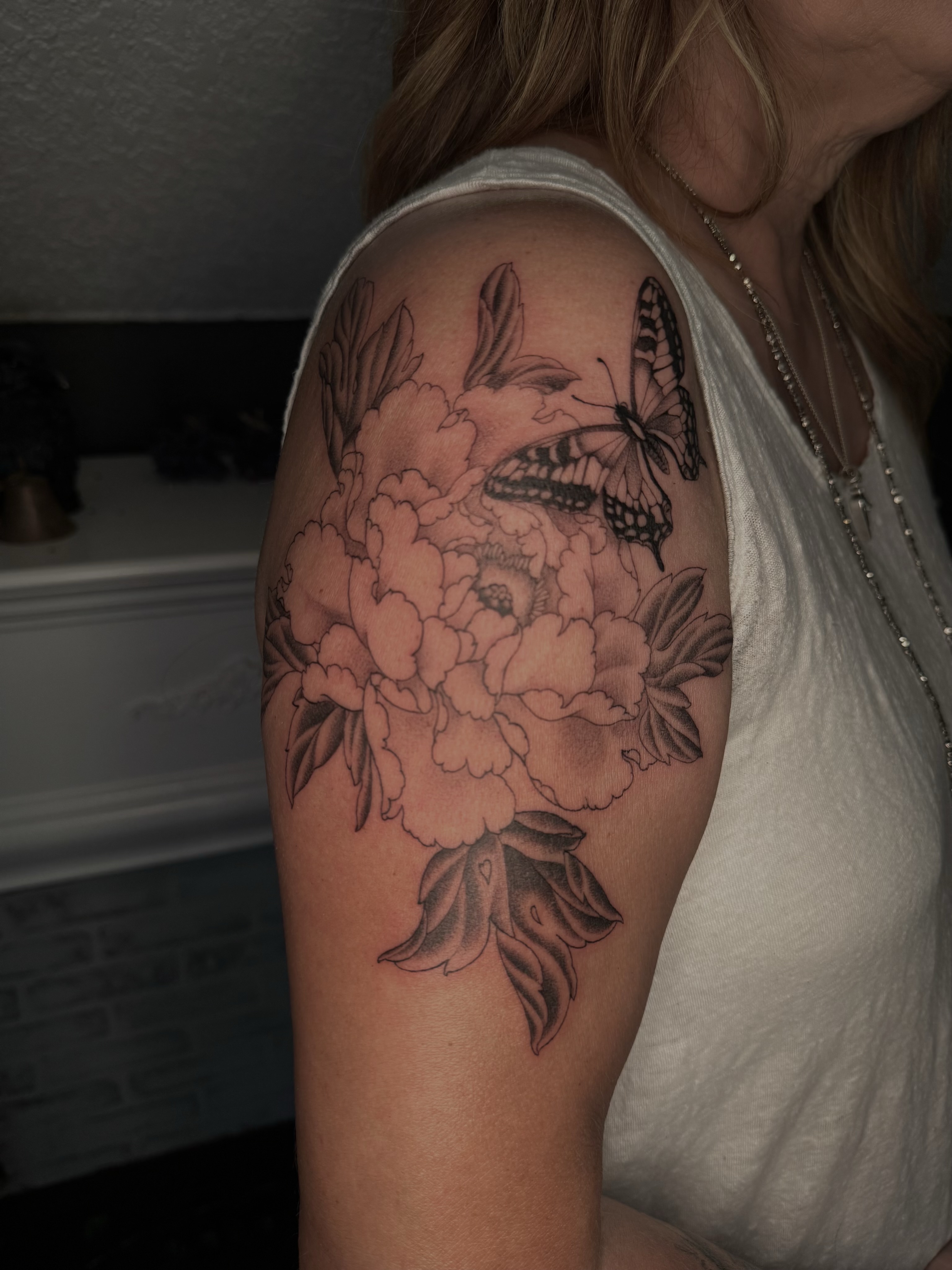 Peony and butterfly black and grey tattoo on the upper arm by Virginia 🥀Neo Traditional