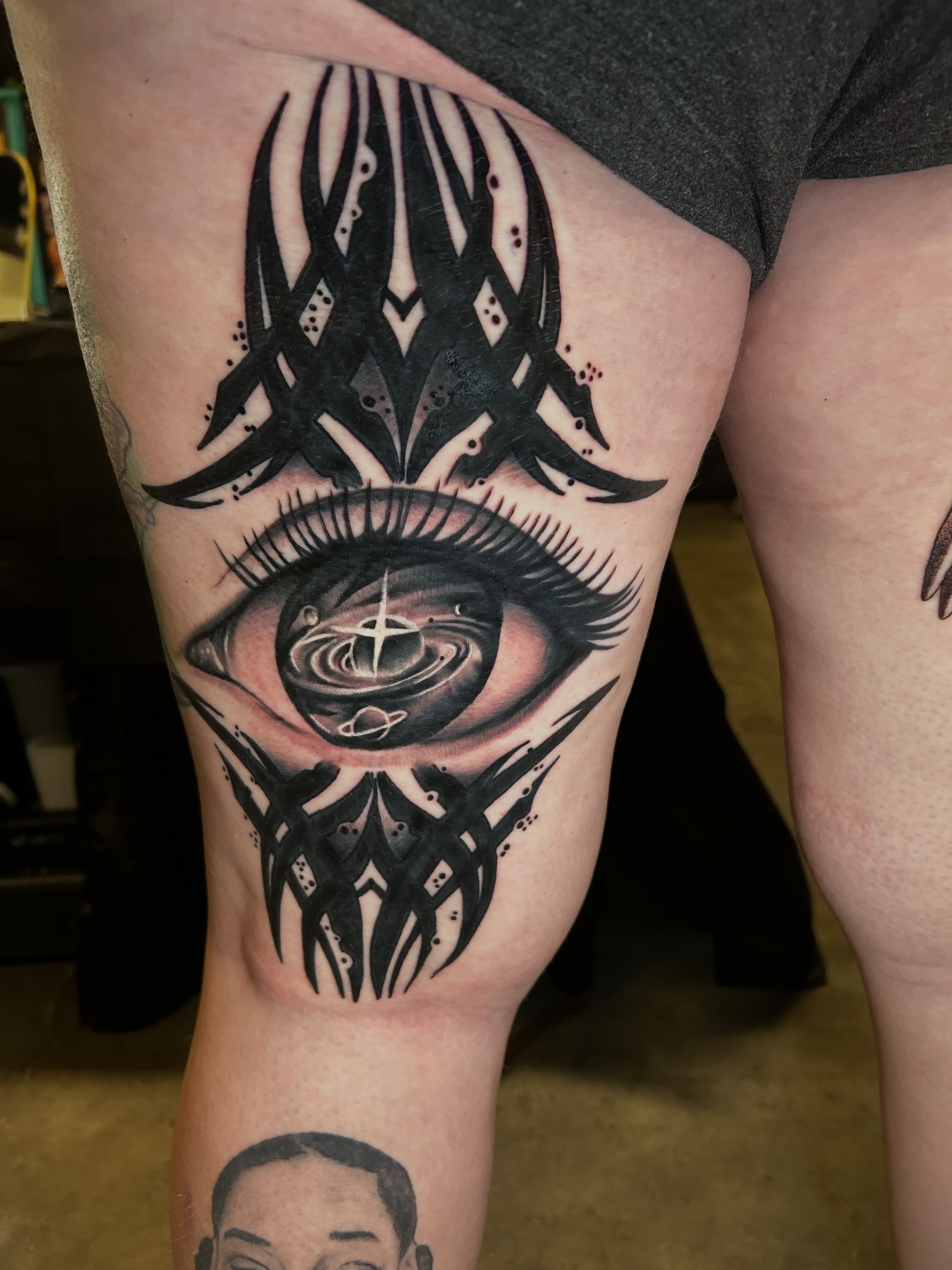 Eye with cosmic design geometric tattoo on the thigh by Austin Young
