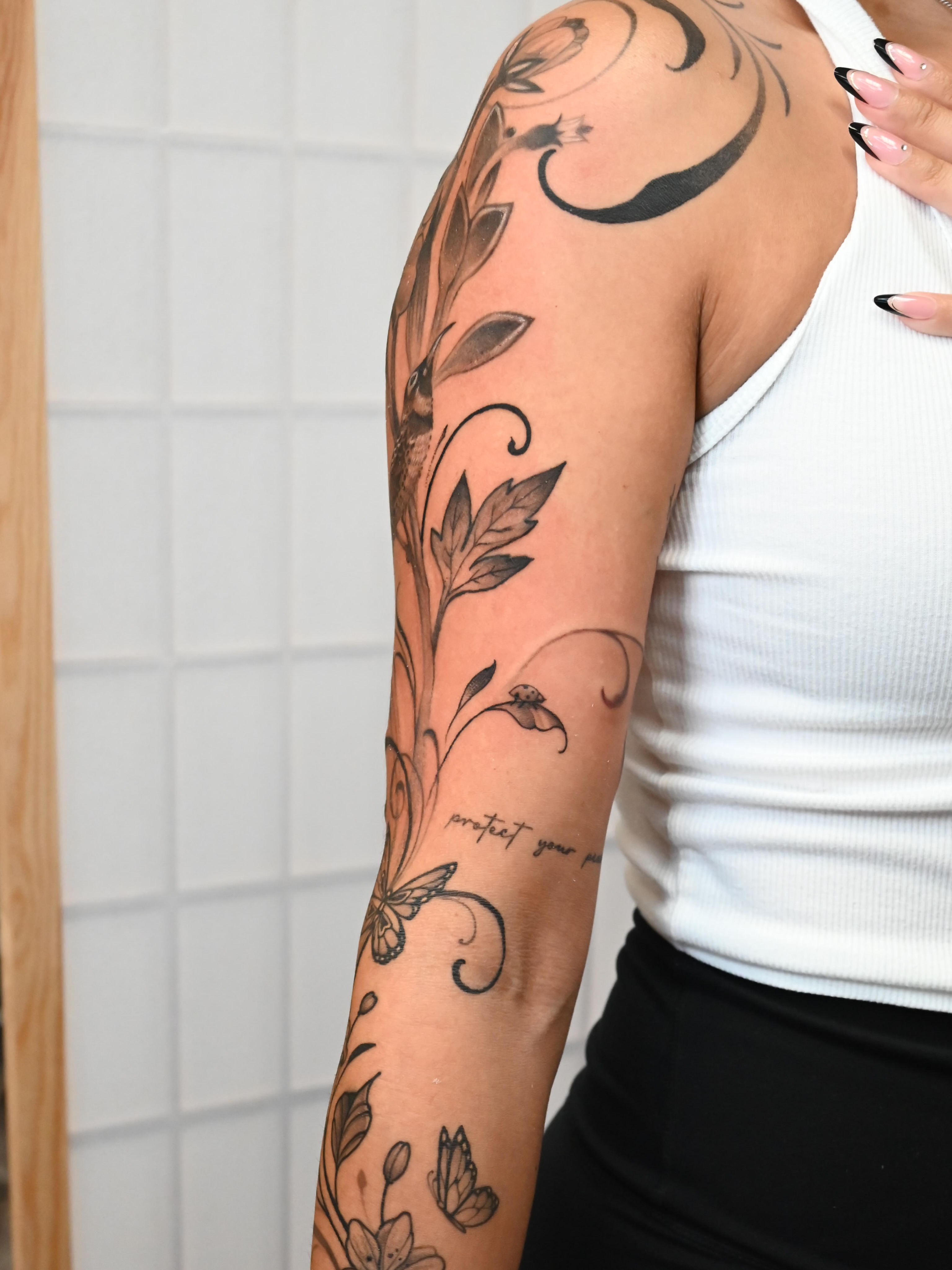 Floral vine ornamental tattoo on the upper arm by Neri Gersaint