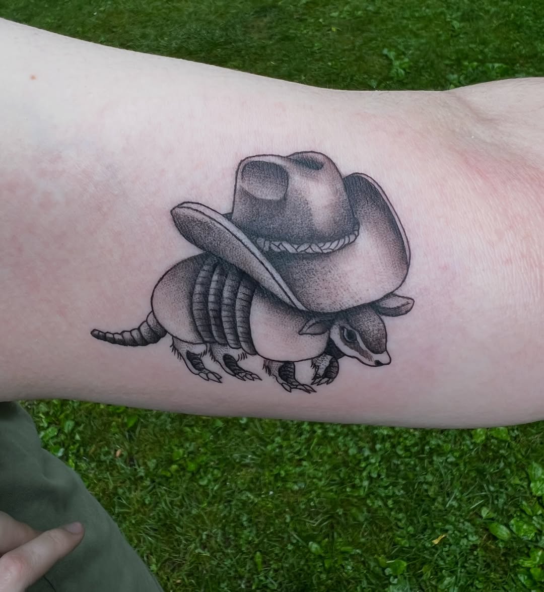 Badger wearing cowboy hat black and grey tattoo on the forearm by Cuda
