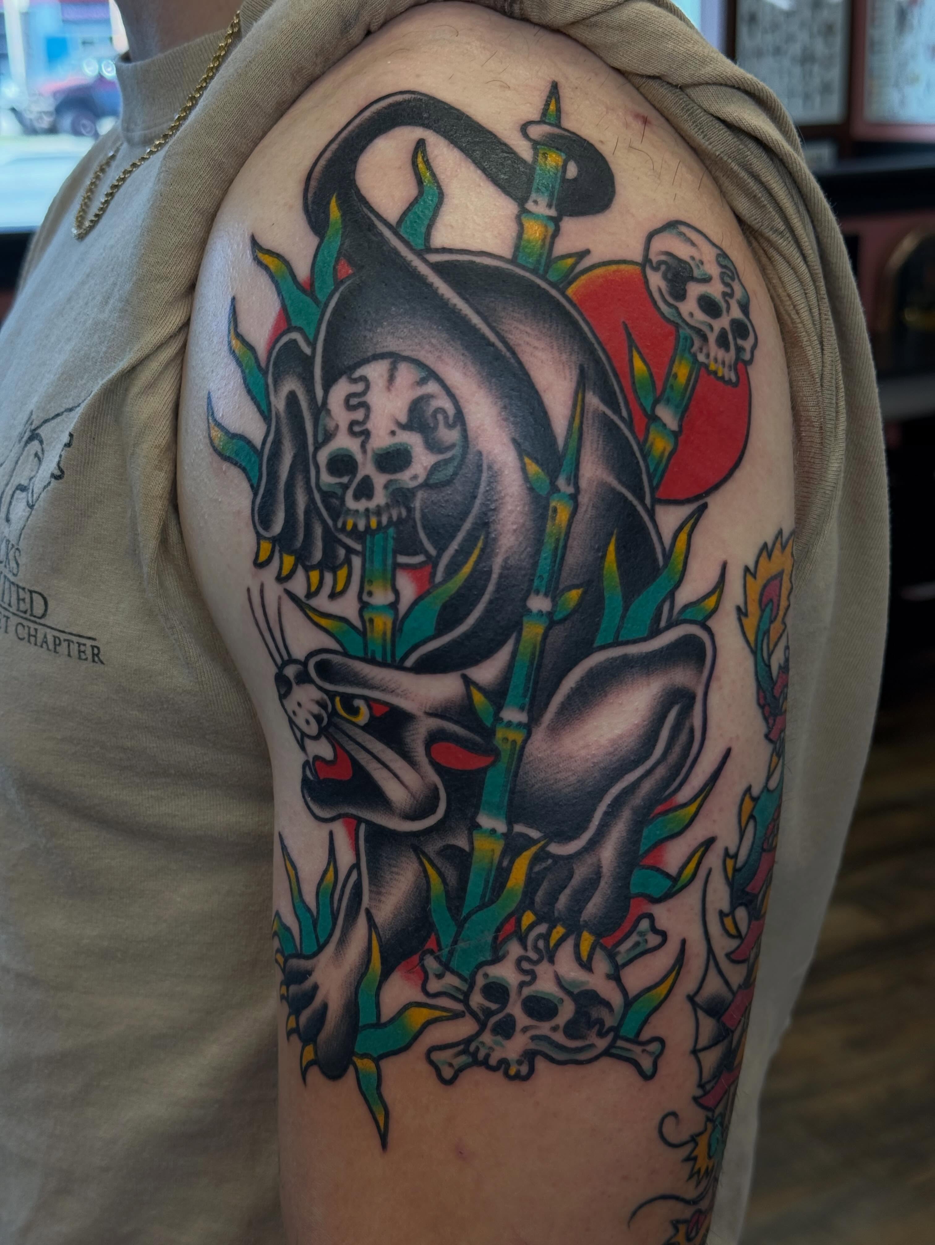 Reaper and skulls American traditional tattoo on the upper arm by Big Al