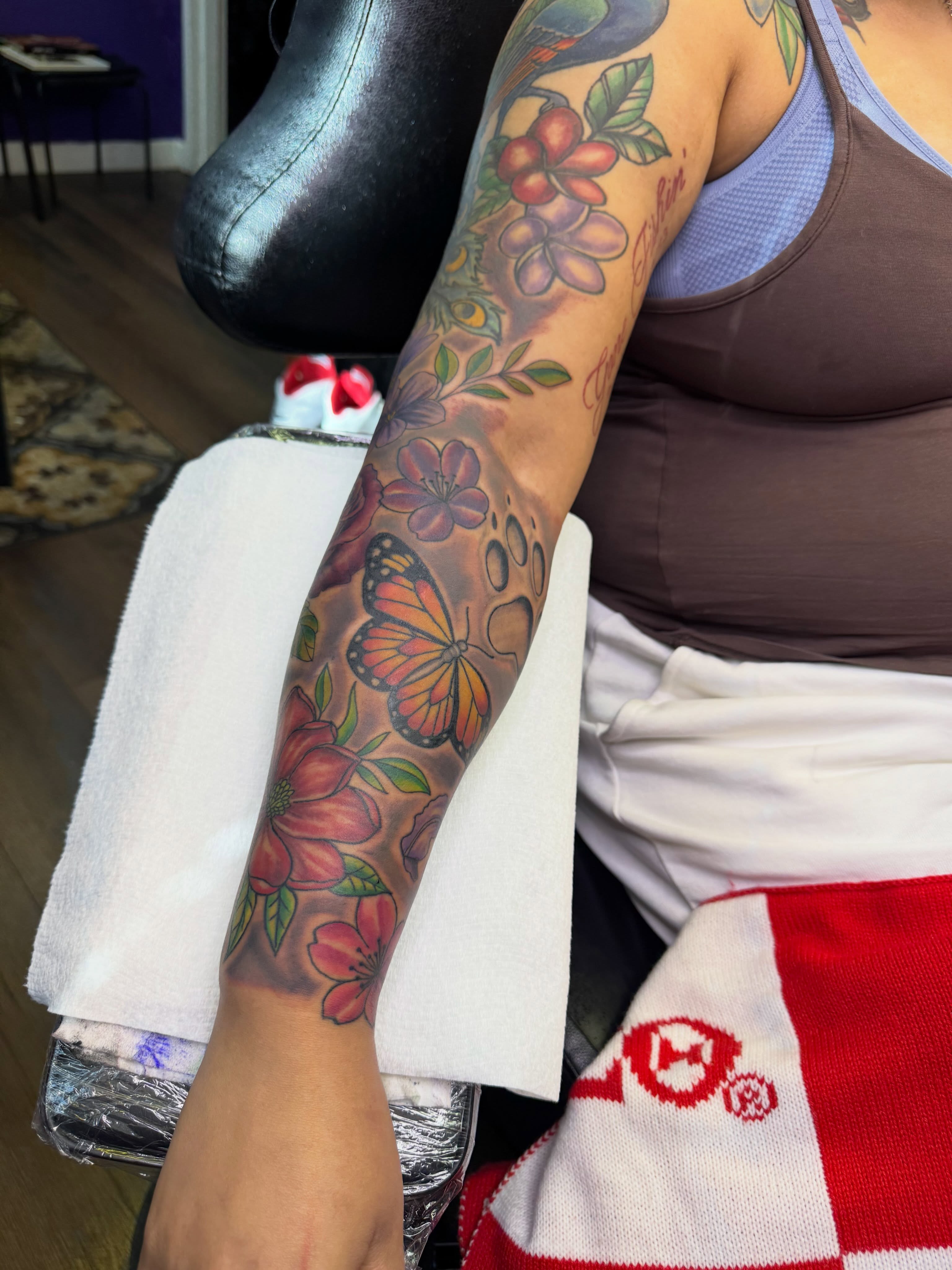 Butterfly and flowers American traditional tattoo on the forearm by Christian Goines, Memphis, Tennessee