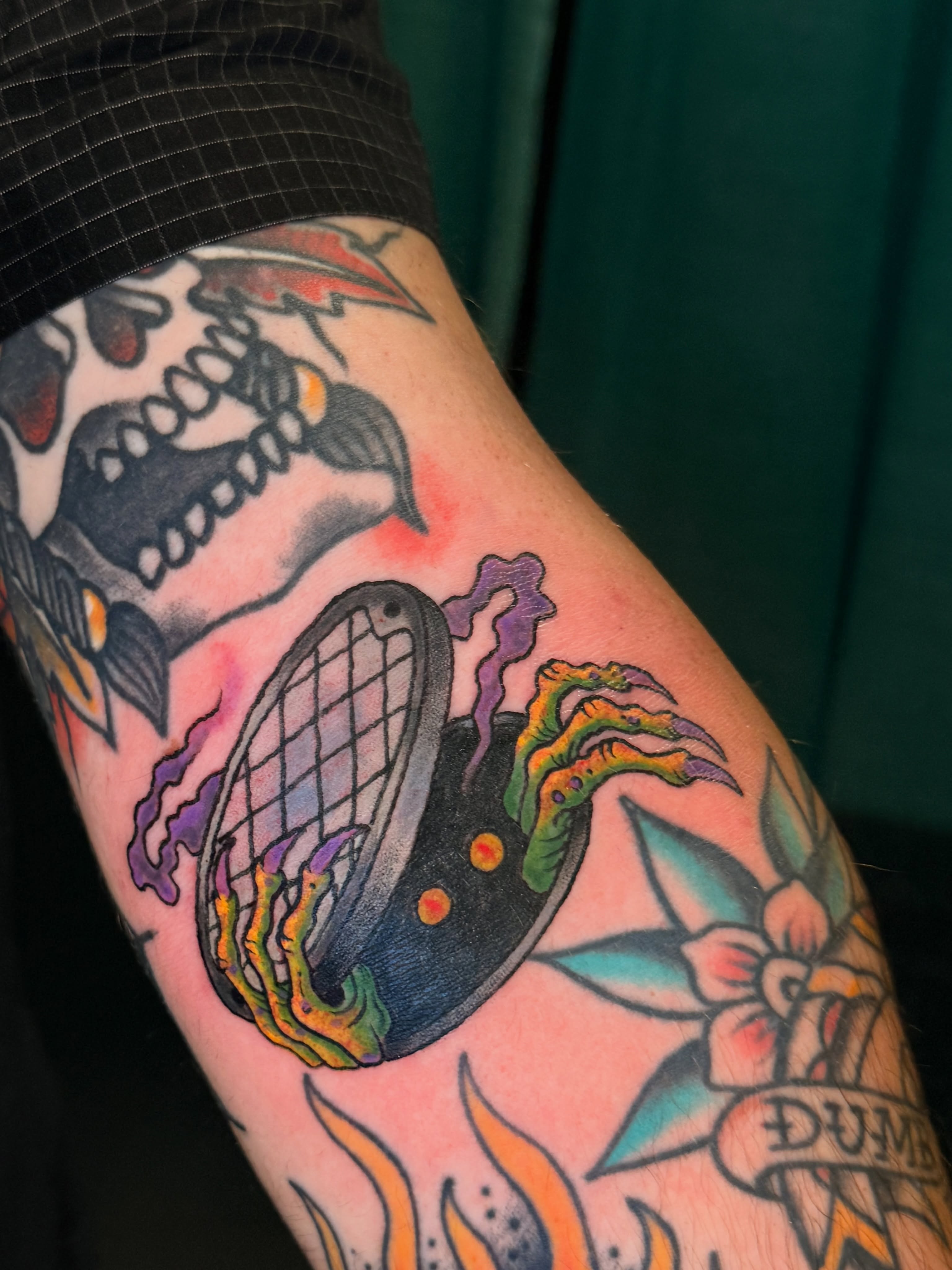 Tennis racket and flames American traditional tattoo on the forearm by Ty Hamilton