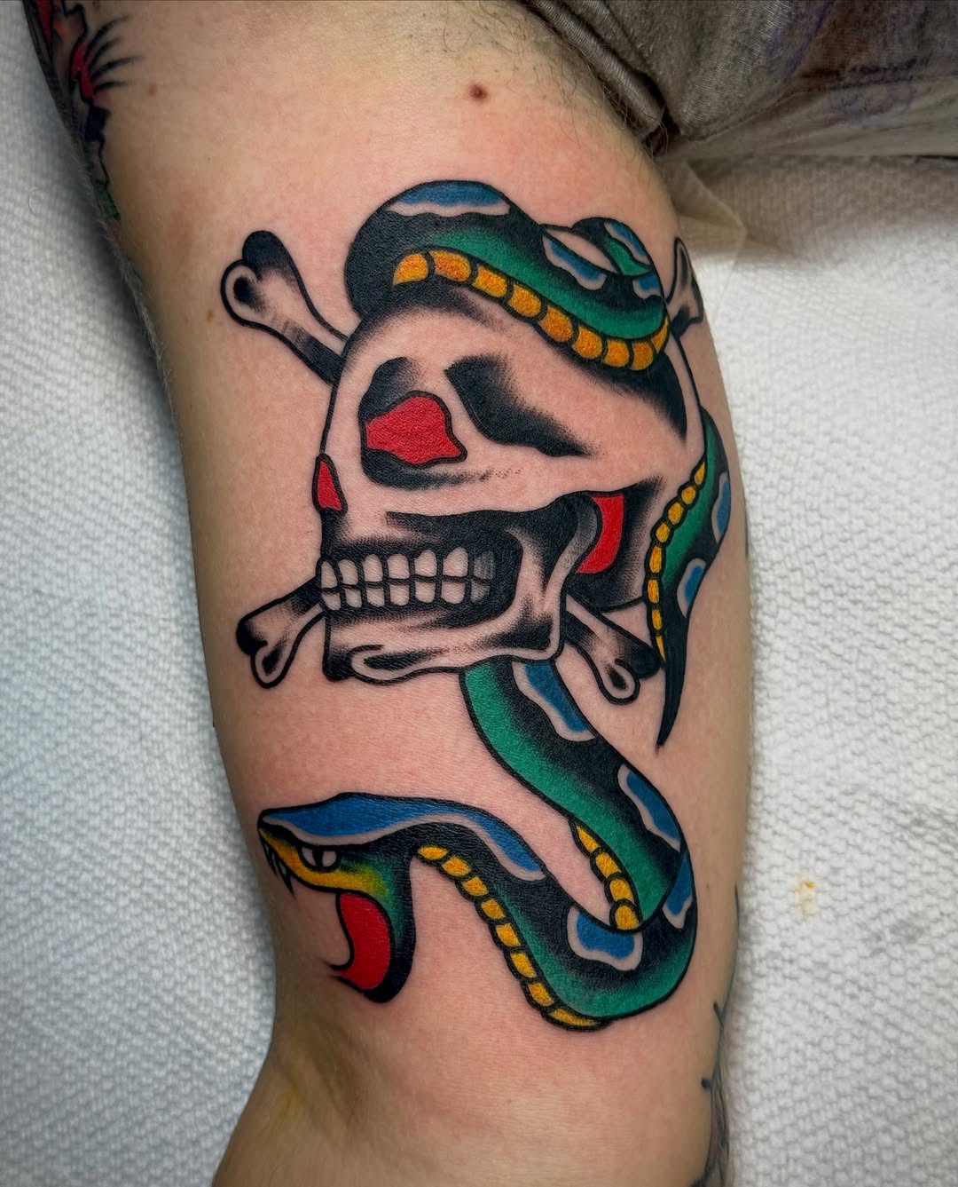 Skull and snake American traditional tattoo on the forearm by Chuck Derek Whitaker