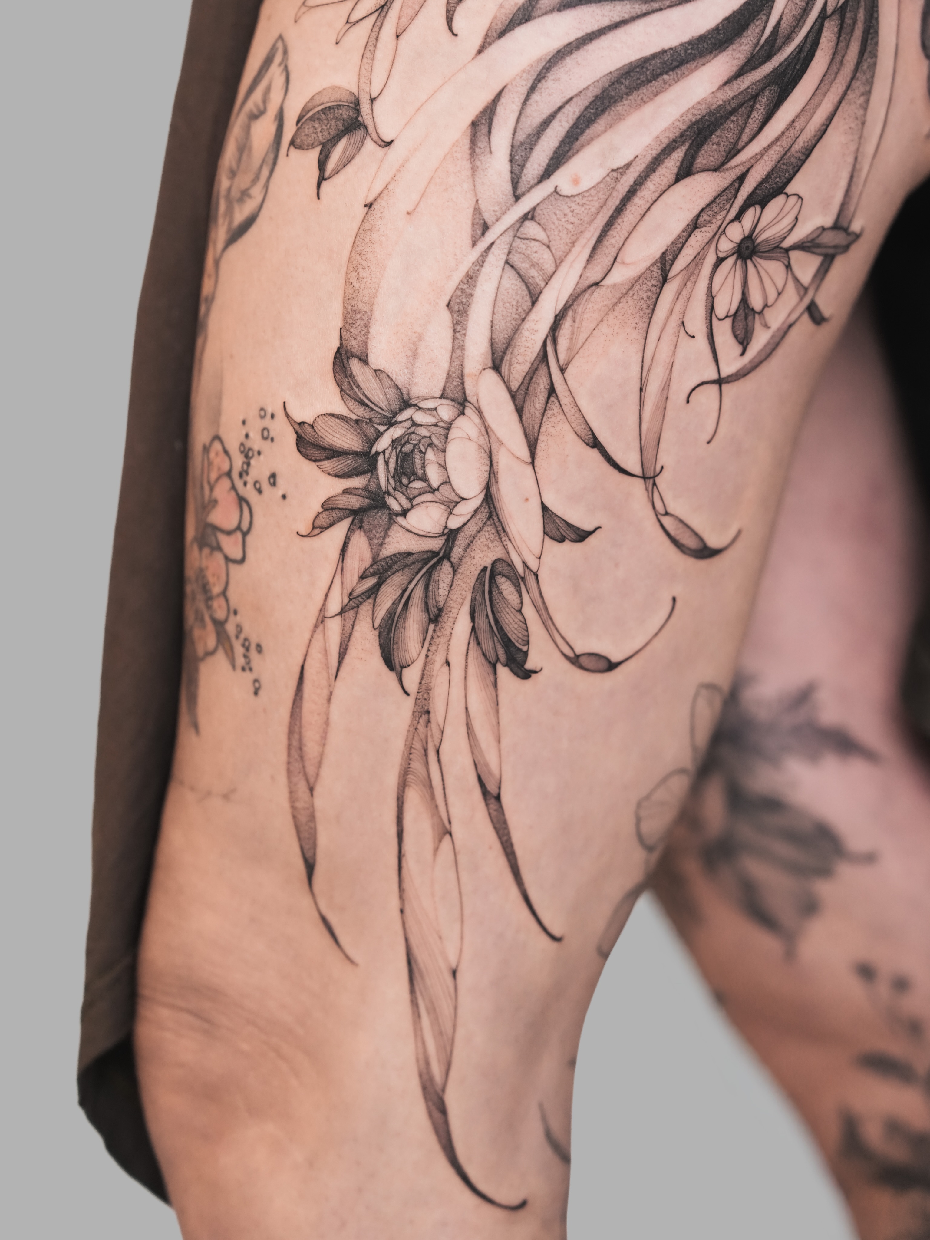 Floral design black and grey tattoo on the thigh by Yuliia Babych tattoo AUSTIN