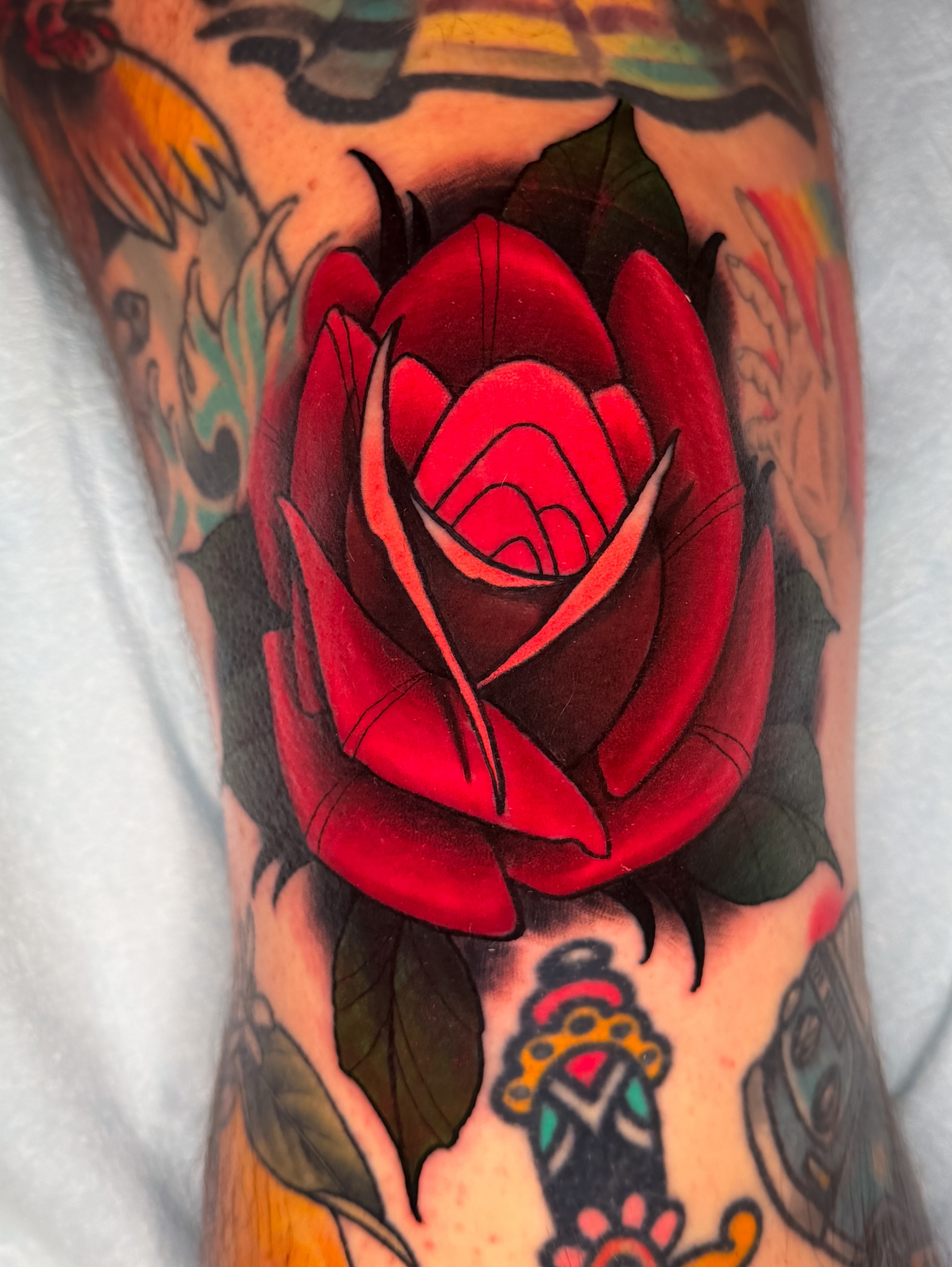Red rose American traditional tattoo on the forearm by Austin Britt