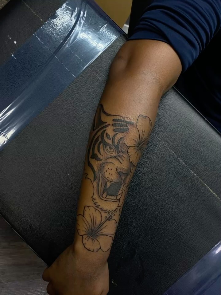 Tiger and hibiscus black and grey tattoo on the forearm by Mariš¤, Chicago, Illinois