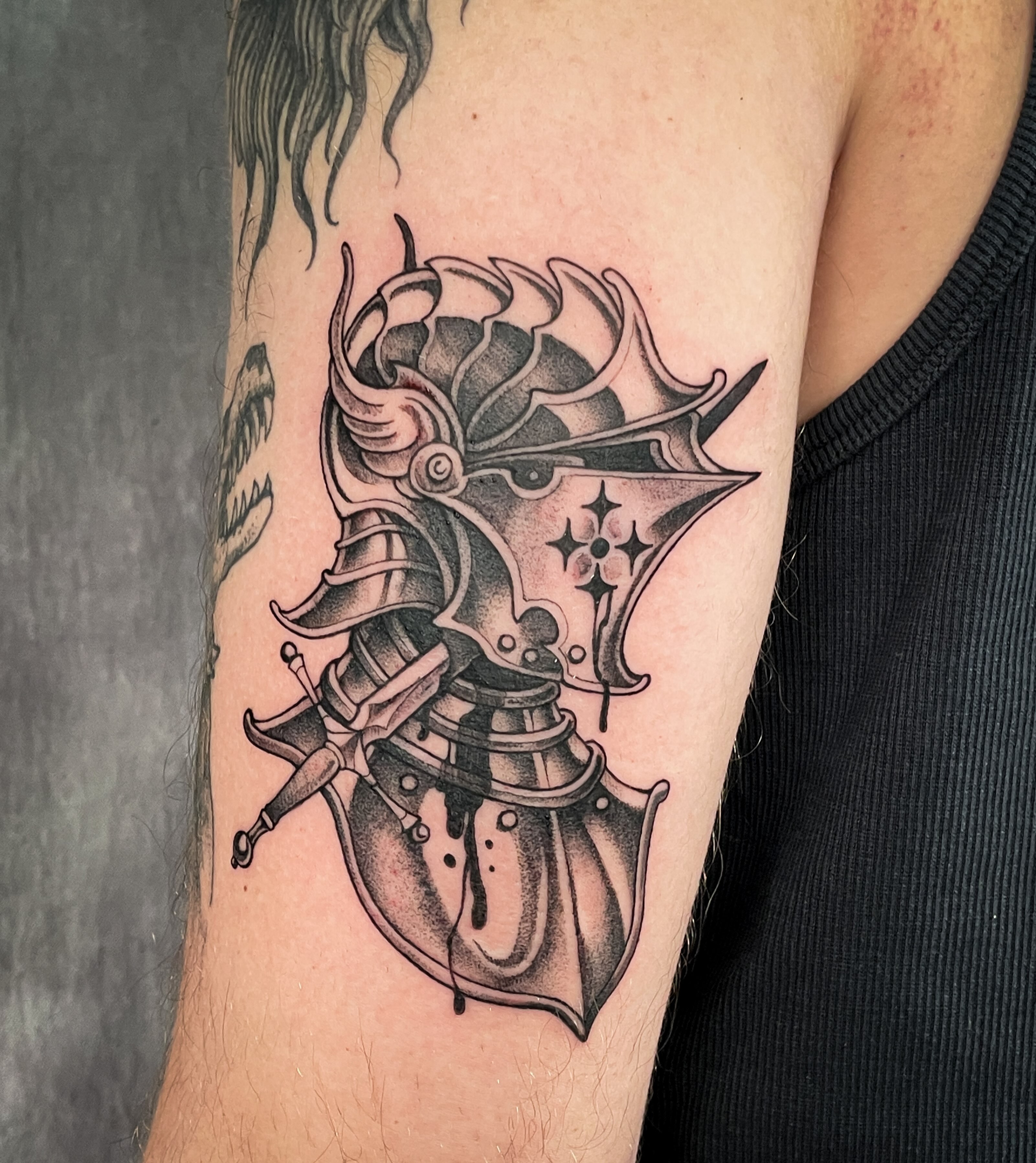 Helmet and sword black and grey tattoo on the forearm by 𝖂𝖍𝖆𝖙𝕽𝖊𝖎𝖑𝖊𝖞