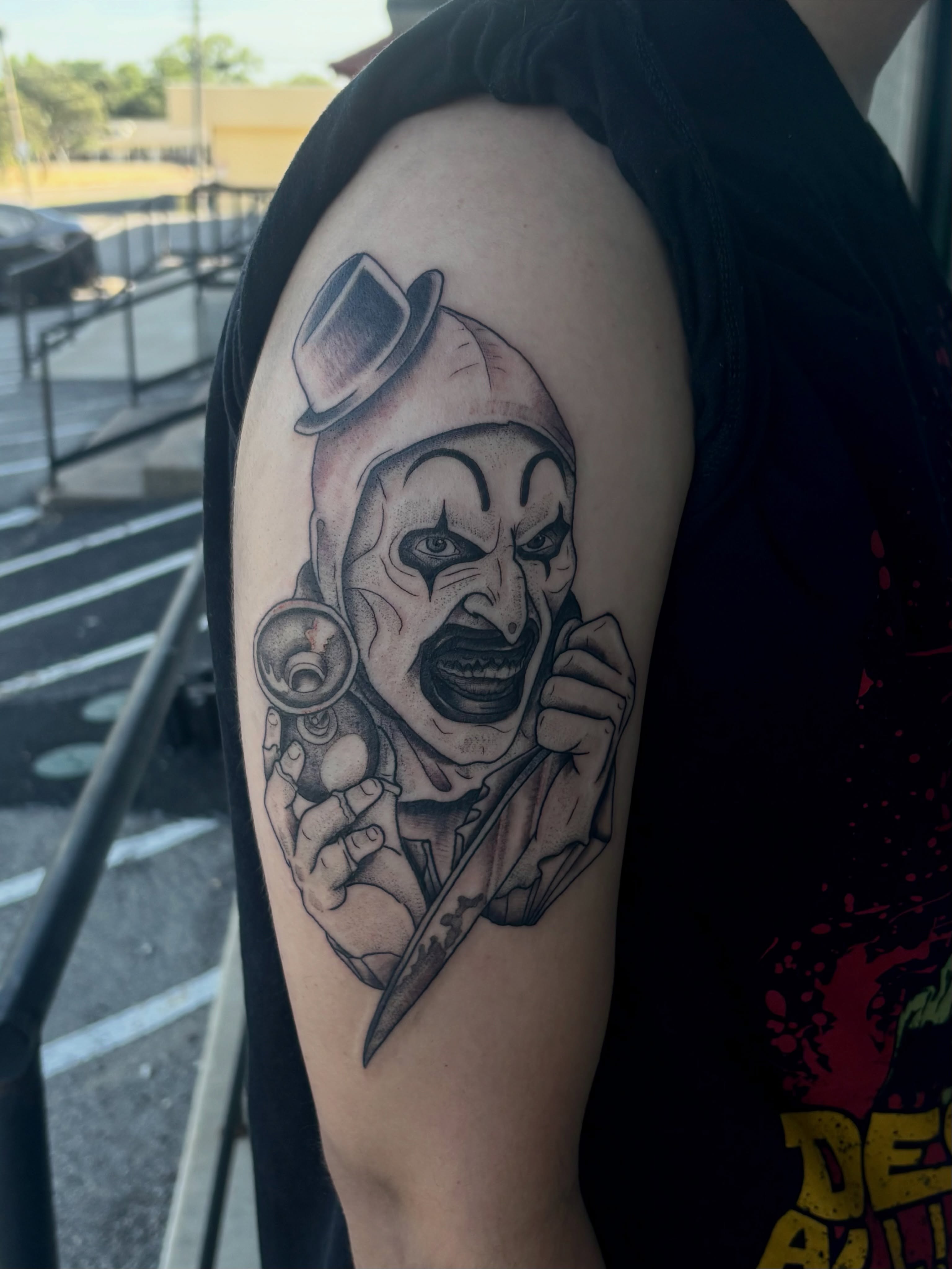 Clown realism tattoo on the upper arm by 🔥Zoë Zahasky Tattoos🔥