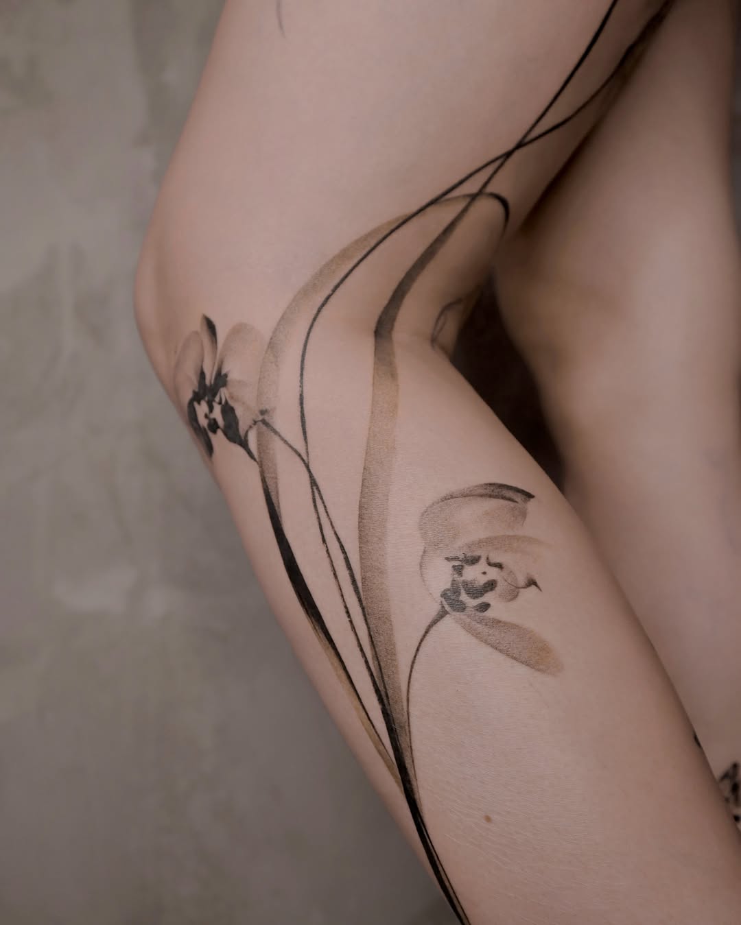 Floral design black and grey tattoo on the thigh by River, New York, New York